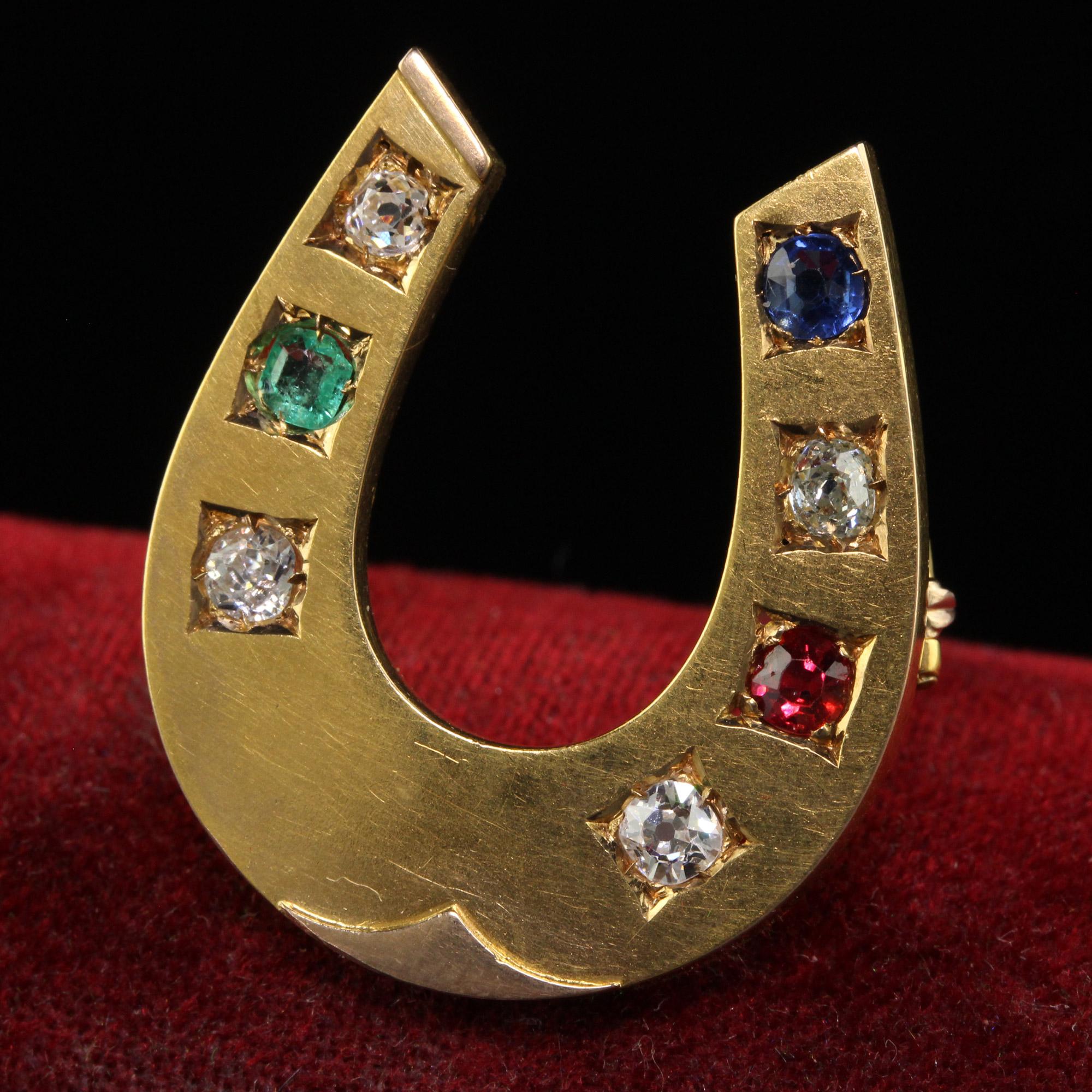 Beautiful Antique Victorian 18K Gold Old Mine Diamond Ruby Sapphire Emerald Horseshoe Pin. This gorgeous Victorian horseshoe pin is crafted in 18k yellow gold. The top of the pin holds four old mine cut diamonds with a single natural sapphire, ruby,