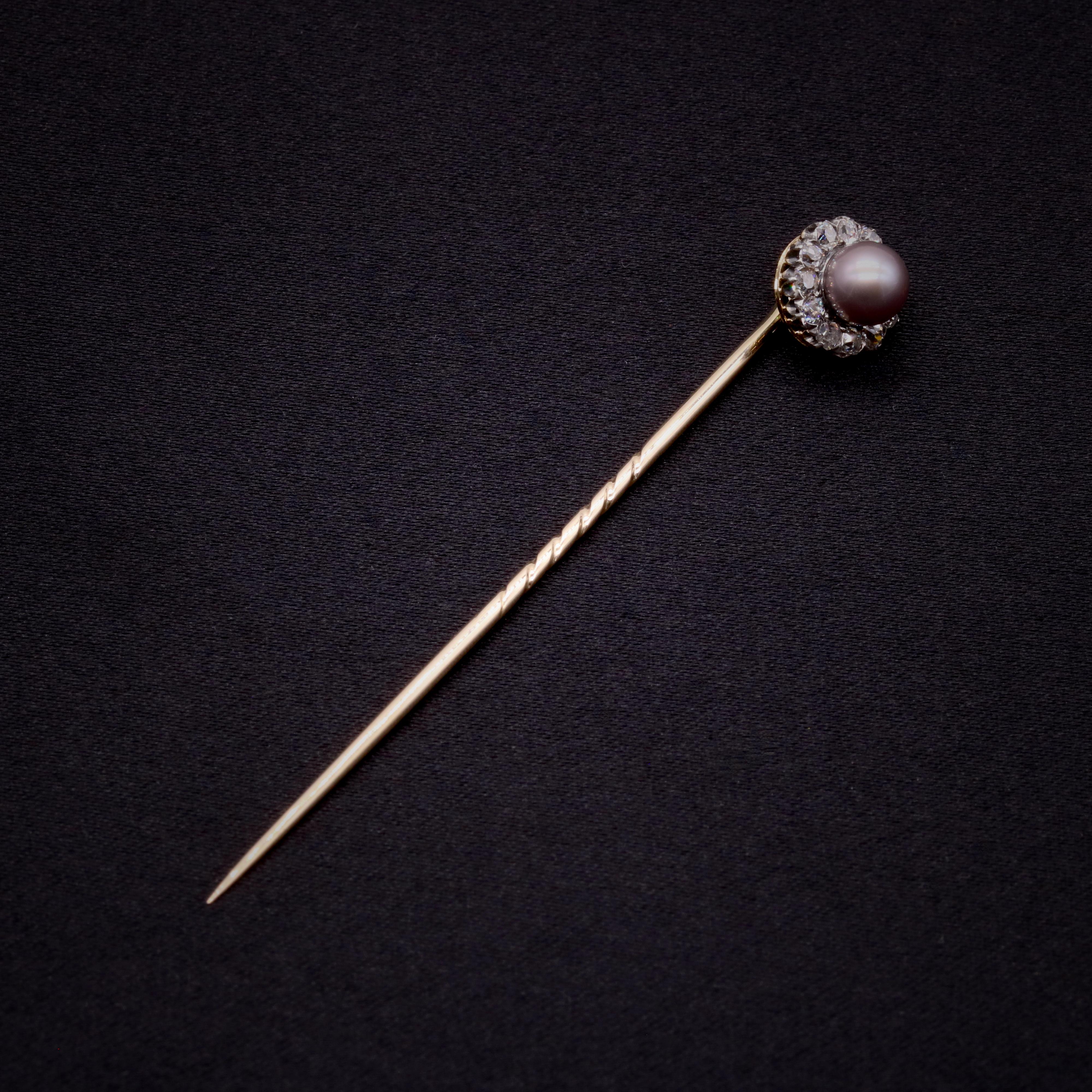 A Victorian pearl, diamond, silver and yellow gold stick pin, comprising one round pearl, twelve old mine cut diamonds, set in silver, with a 18 karat yellow gold pin and back. 

This elegant stick pin is set to the centre with a shimmering pearl.