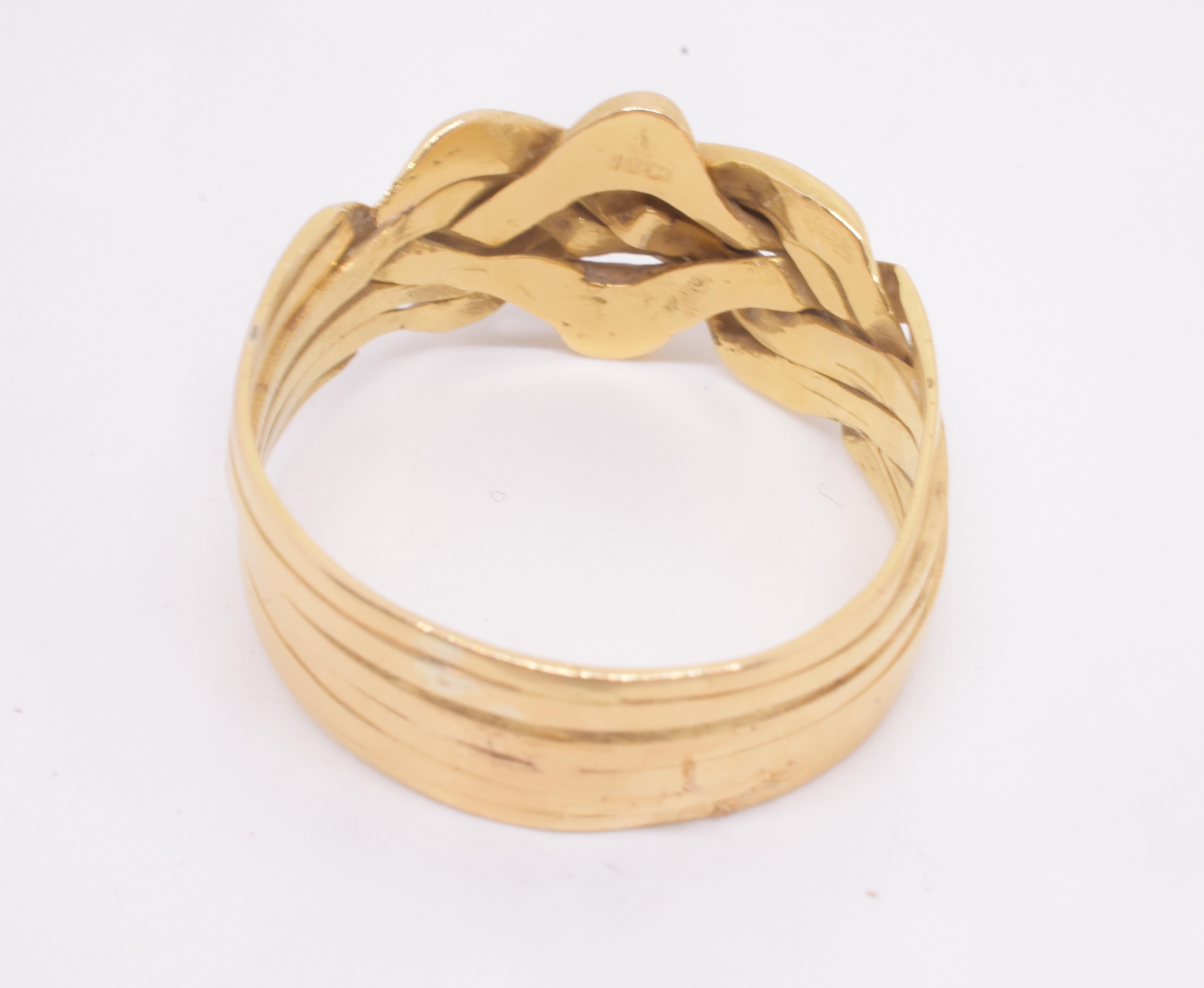 Une bague de puzzle antique en or jaune riche et onctueux de 18 carats. Cette bague-puzzle comporte 6 bandes, mais elles ne se séparent pas toutes ; elles sont divisées en 2 sections, avec 4 bandes soudées ensemble pour former une section et 2