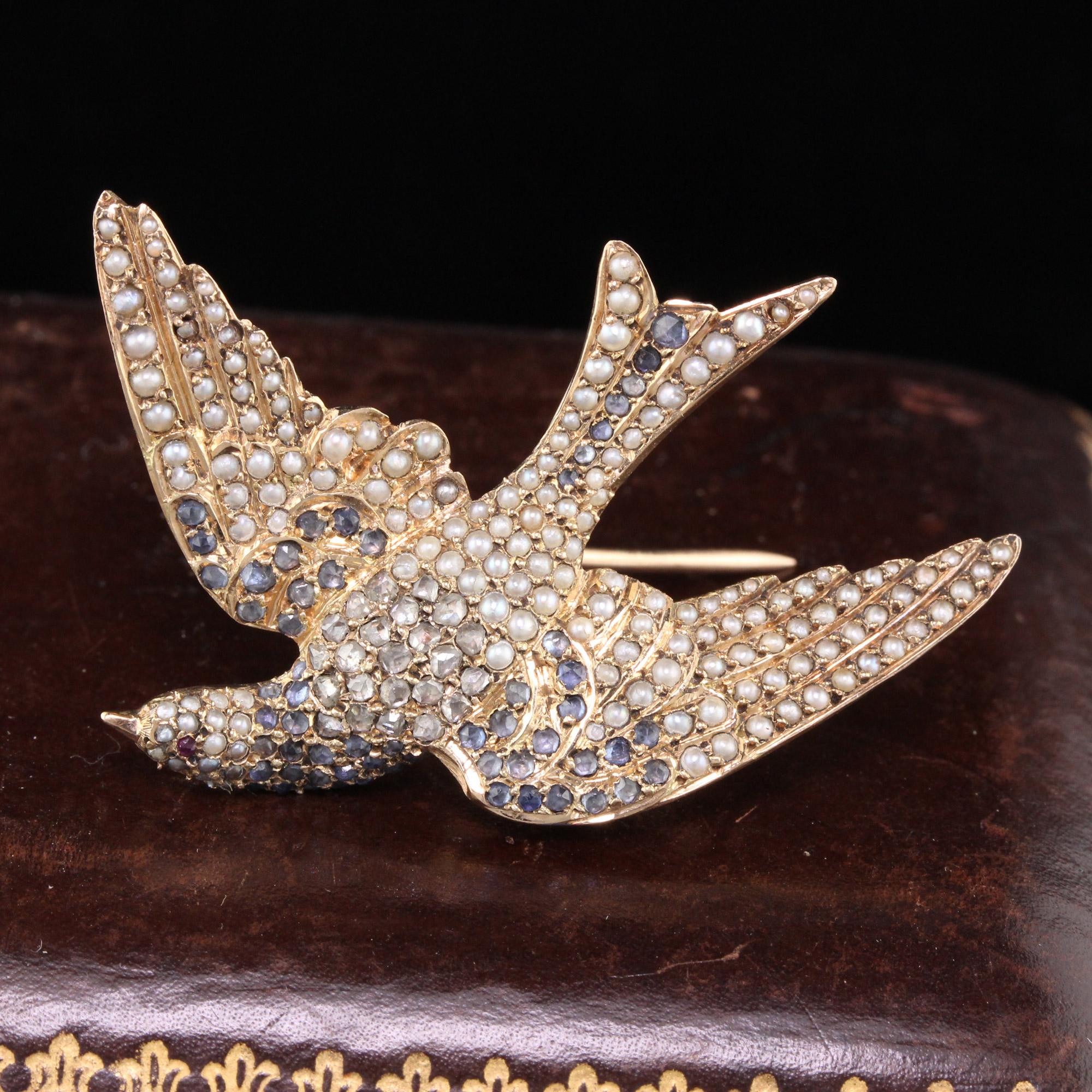 This stunning Victorian bird brooch is done in 18K rose gold with seed pearls, rose cut diamonds, and light blue sapphires. There is one ruby as the birds eye. 

Metal: 18K Rose Gold 

Weight: 12.5 Grams 

Measurements: 43.3 x 22 mm
