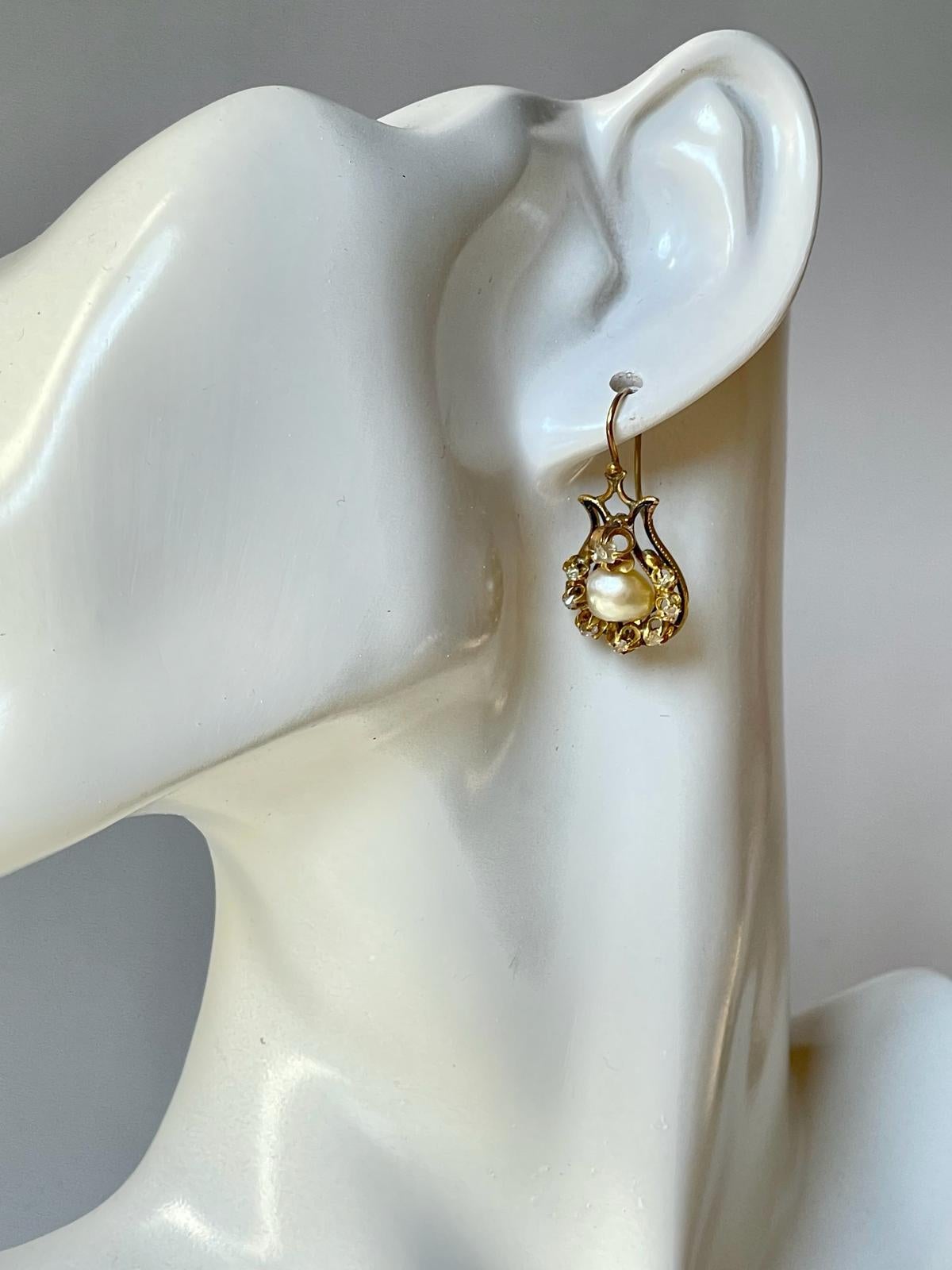 A lovely pair of antique C 1880 late Victorian earrings in black enameled 18K yellow gold highlighted by cushion cut diamonds and centered with 2 certified natural saltwater baroque pearls. The natural saltwater pearls are very rare to find nowadays