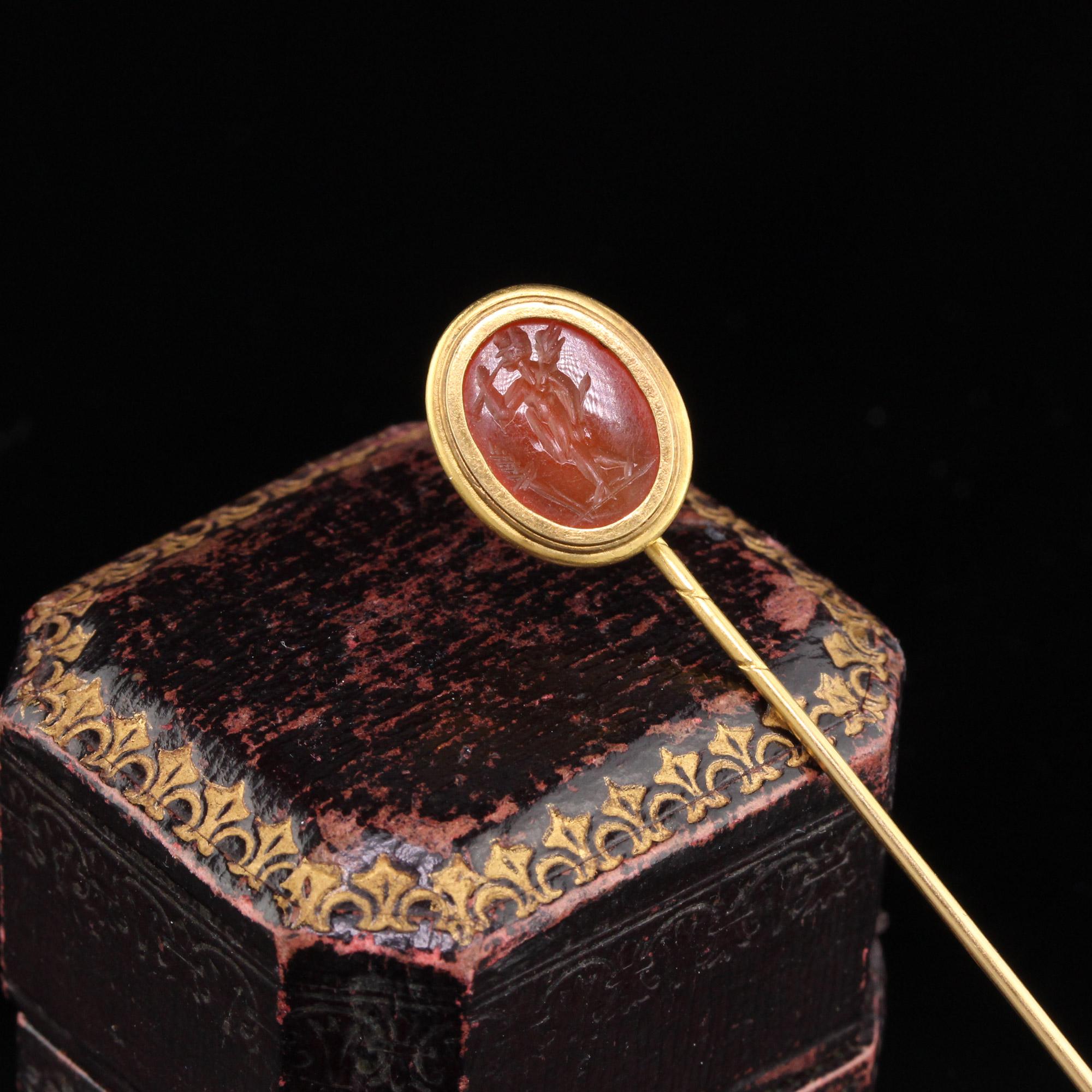 Victorian Stick Pin with a carved carnelian cameo in the center set in a gold bezel. The image on the cameo appears to be of a young man shooting an arrow.

Metal: 18K Yellow Gold

Weight: 2.8 Grams

Measurements: Head measures 14.5 x 11.76 mm