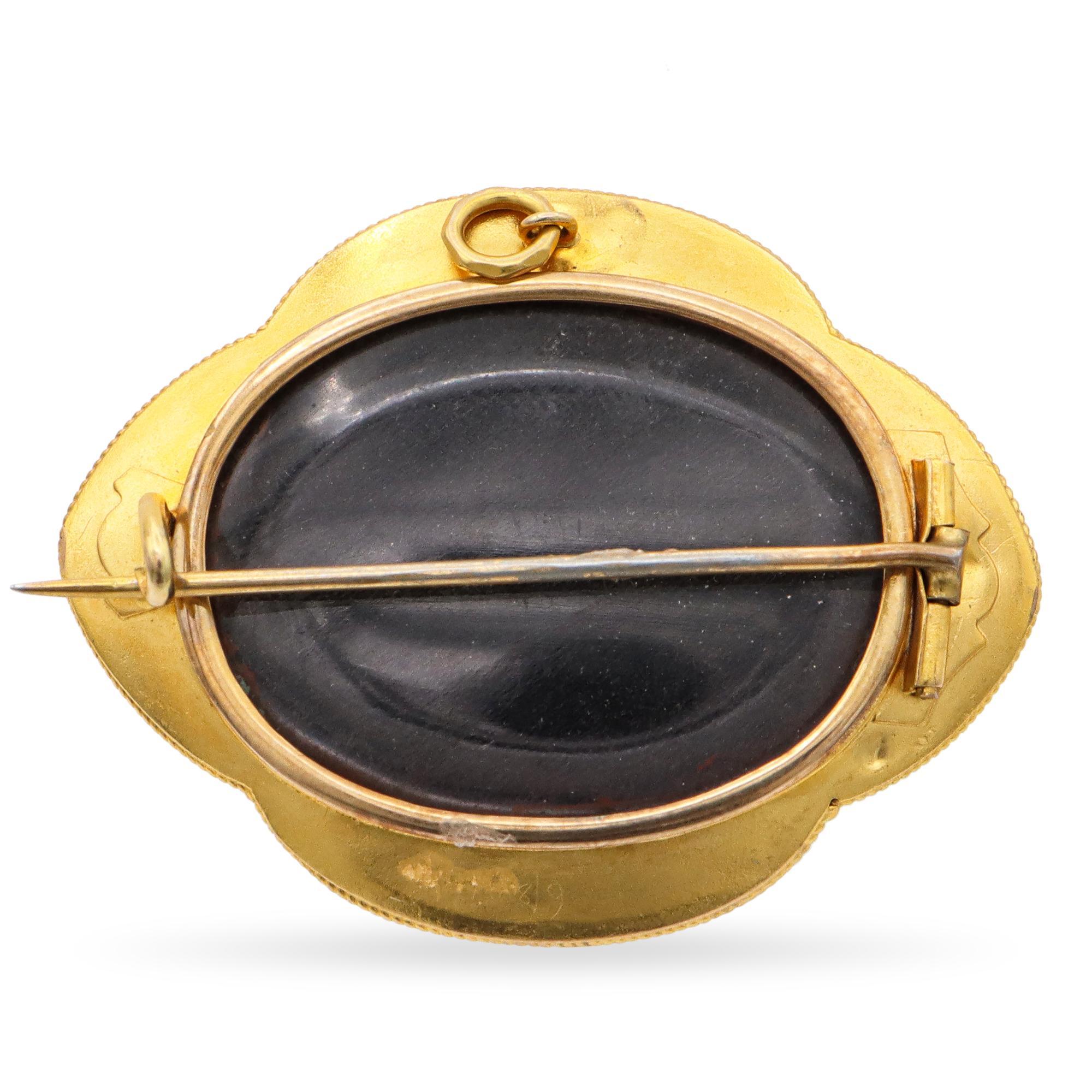 This antique 18k yellow gold brooch pendant is a superb example of mid-19th century mourning jewelry, expertly crafted with intricate detailing and symbolic design. The central raised oval features a finely executed starburst motif in relief.