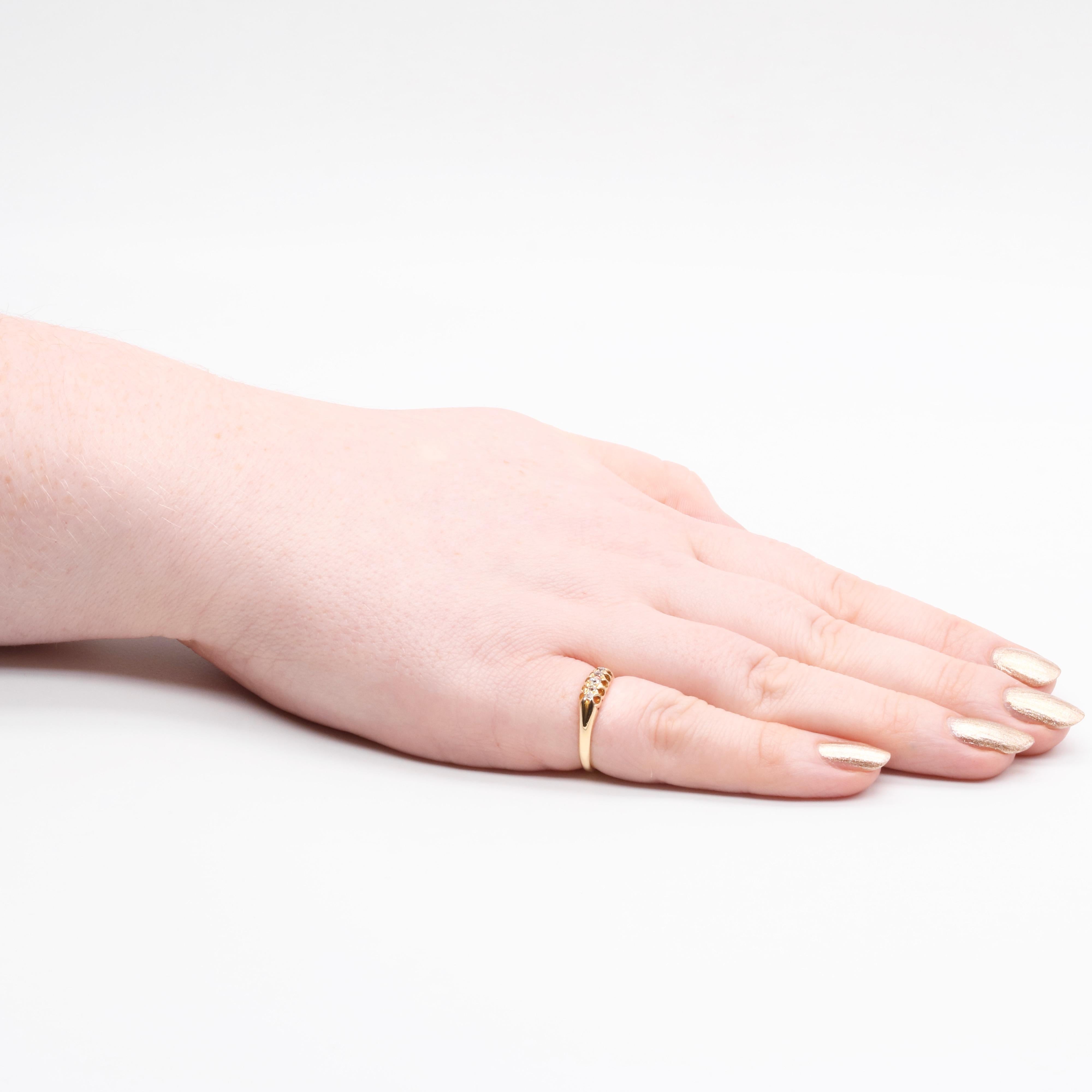 An antique diamond and yellow gold ring, comprising five old cut diamonds, set in 18 karat yellow gold, to a band of 18 karat yellow gold. 

The ring is set with 5 sparkling diamonds, which graduate from the centre out. The largest central diamond