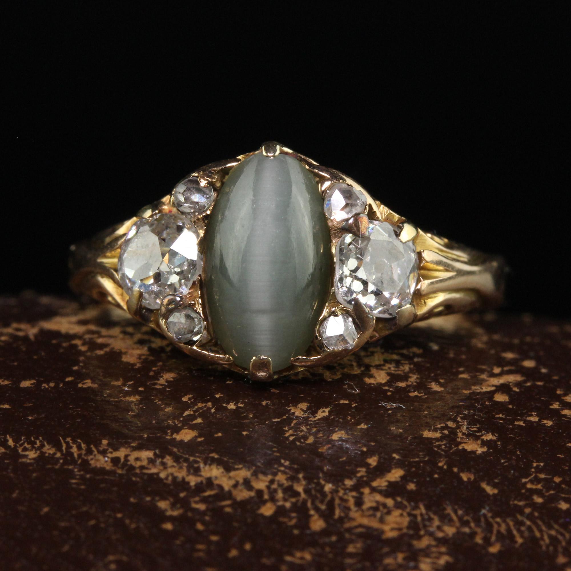 Beautiful Antique Victorian 18K Yellow Gold Old Mine Diamond and Cats Eye Chrysoberyl Ring. This beautiful Victorian diamond ring is crafted in 18k yellow gold. The center holds a beautiful cabochon cats eye chrysoberyl and has old mine cut diamonds