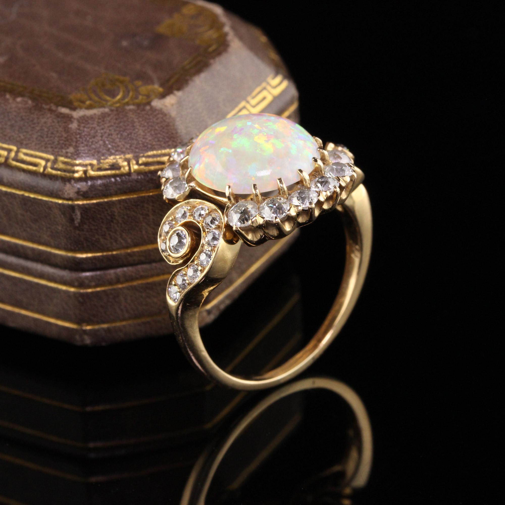 Beautiful Antique Victorian 18K Yellow Gold Old Mine Diamond and Opal Ring. This unbelievable Victorian opal ring features a bright and lively opal that has a beautiful fiery play of color surrounded by chunky old mine cut diamonds. This ring is