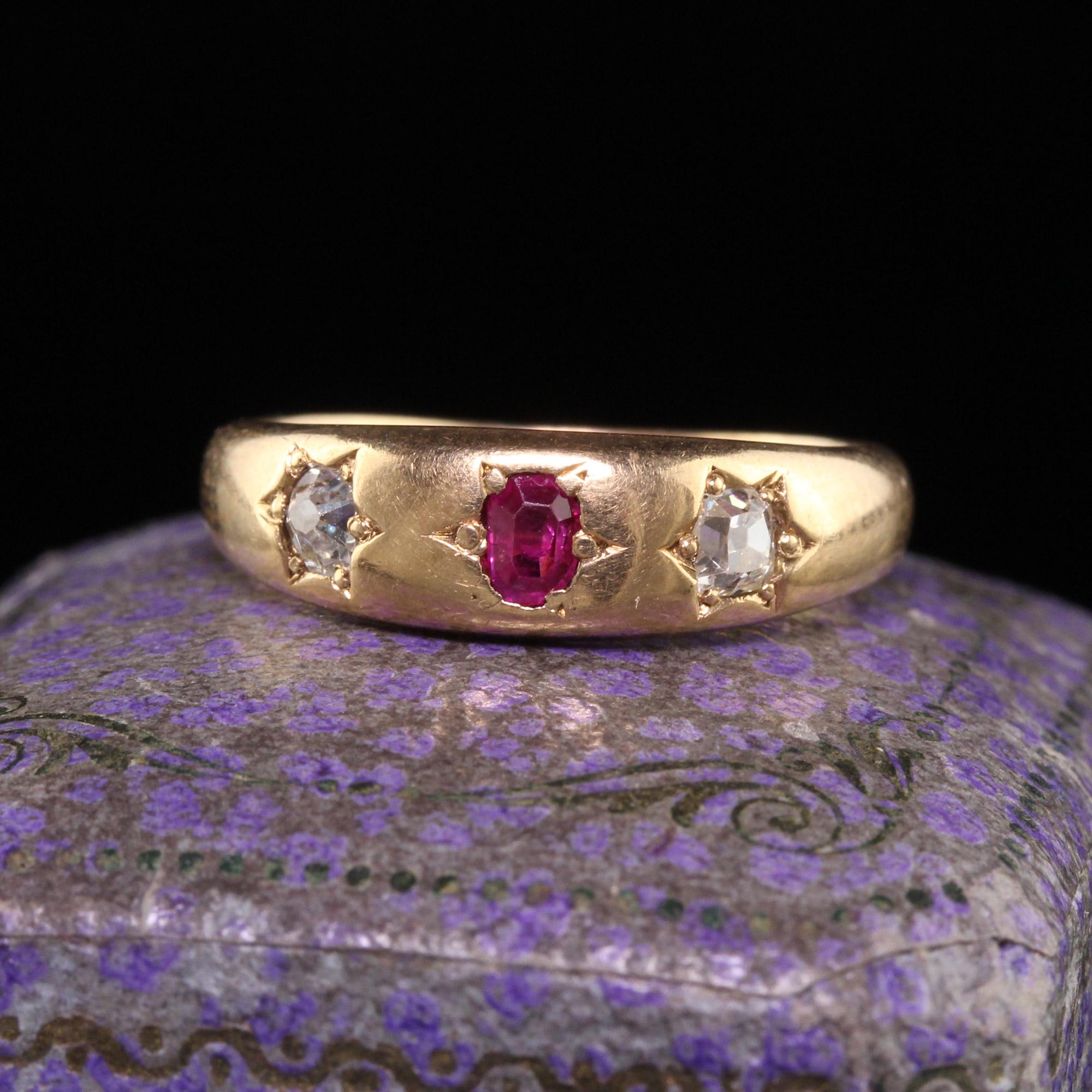 Beautiful Antique Victorian 18K Yellow Gold Old Mine Diamond and Ruby Three Stone Ring. This classic band is crafted in 18k yellow gold. The ring holds two old mine cut diamonds and a natural ruby in the center. The ring is in great condition and
