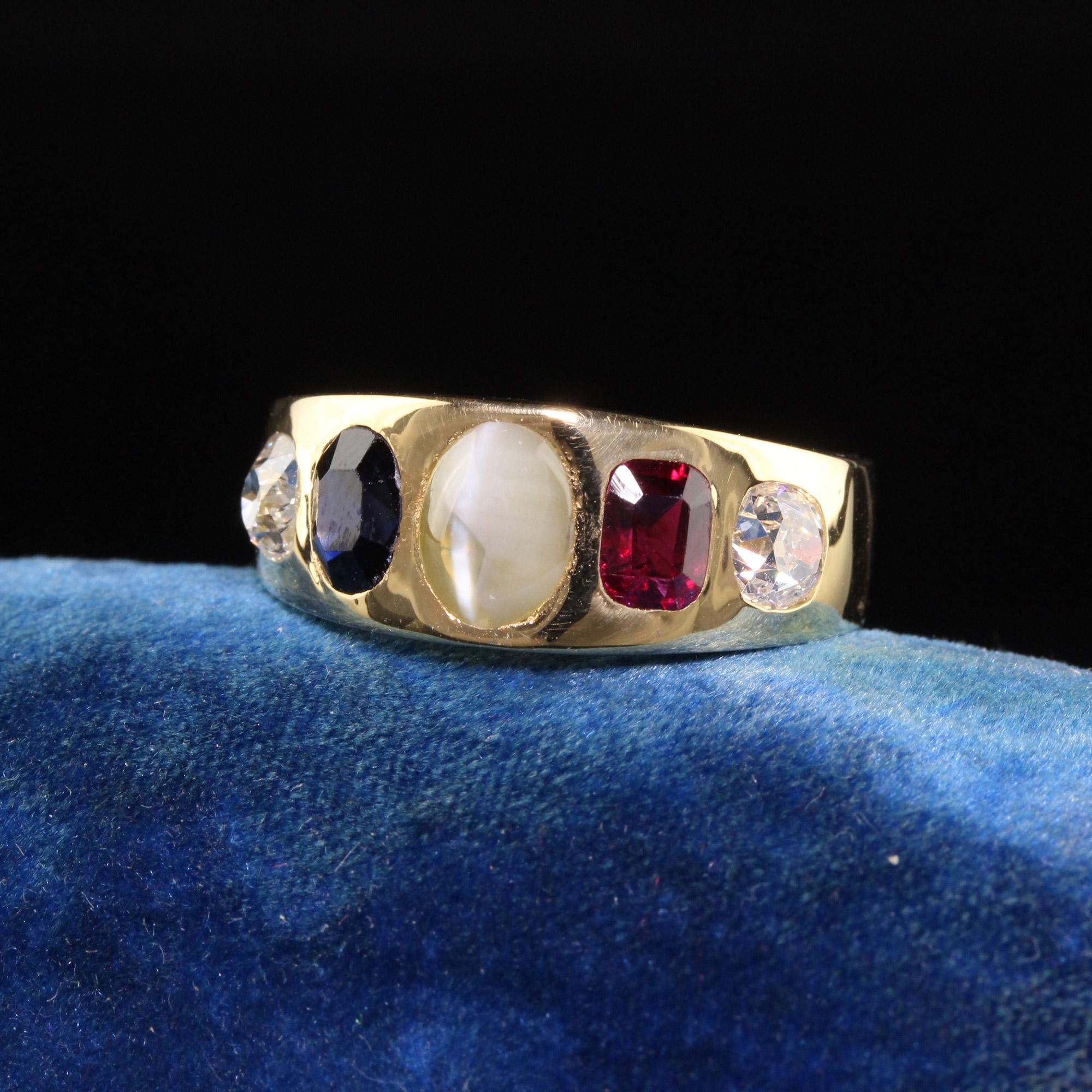 Beautiful Antique Victorian 18K Yellow Gold Old Mine Diamond Ruby Sapphire Flush Set Ring. This incredible ring is crafted in 18k yellow gold. The ring has two chunky old mine cut diamonds on the sides with a natural ruby and sapphire and a cats eye