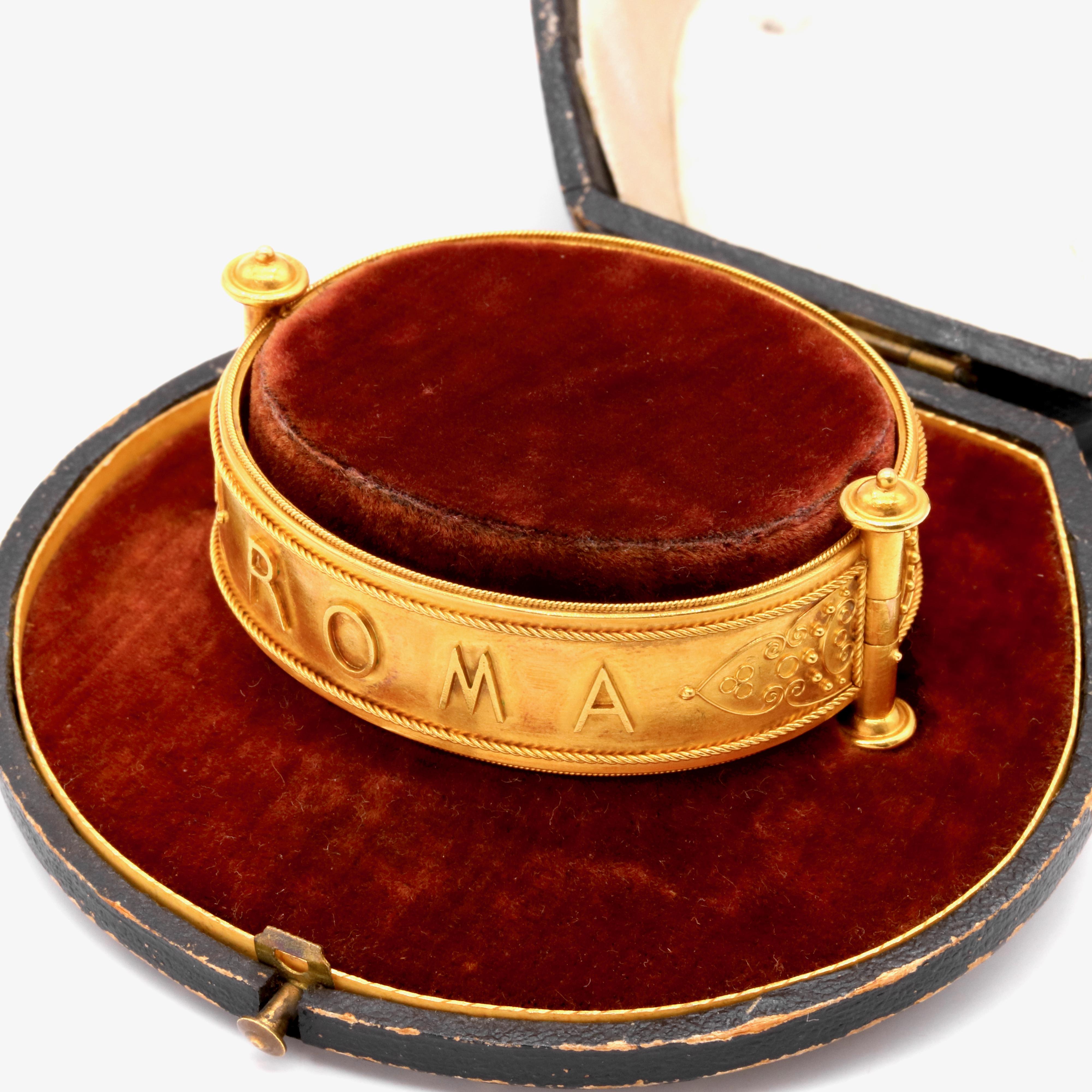 An antique yellow gold bangle, with applied granulation and wirework in 18 karat yellow gold.  

This glorious bangle is in the Etruscan revival style, which was in vogue throughout the Victorian era. The bangle is hinged, and is opened by way of a