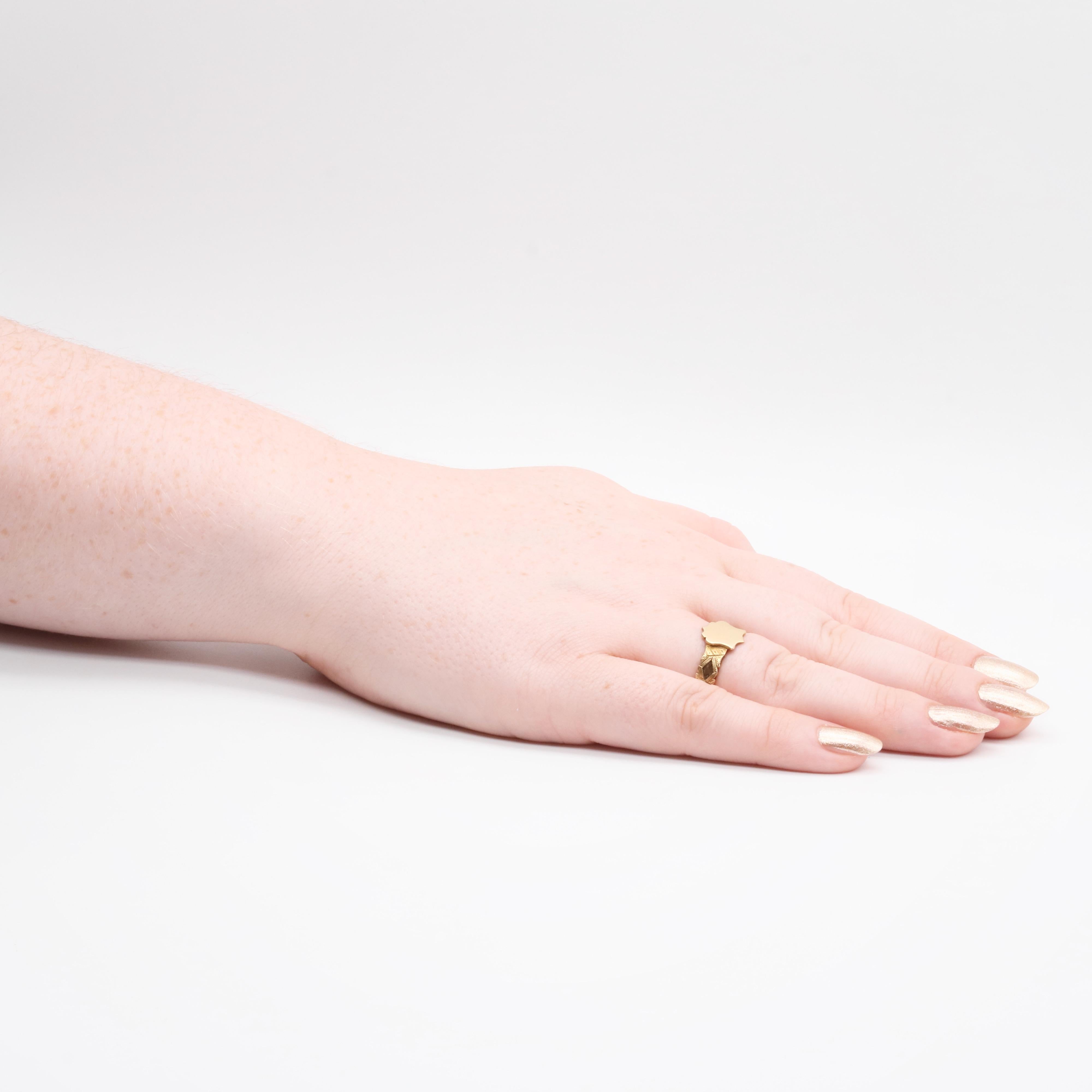 A hairwork ring in yellow gold, comprising plaited brown hair, set in an 18 karat yellow gold band, with an applied shield shaped face. 

This beautiful ring is set to the centre with a curvaceous shield shaped face, which is vacant. The band is