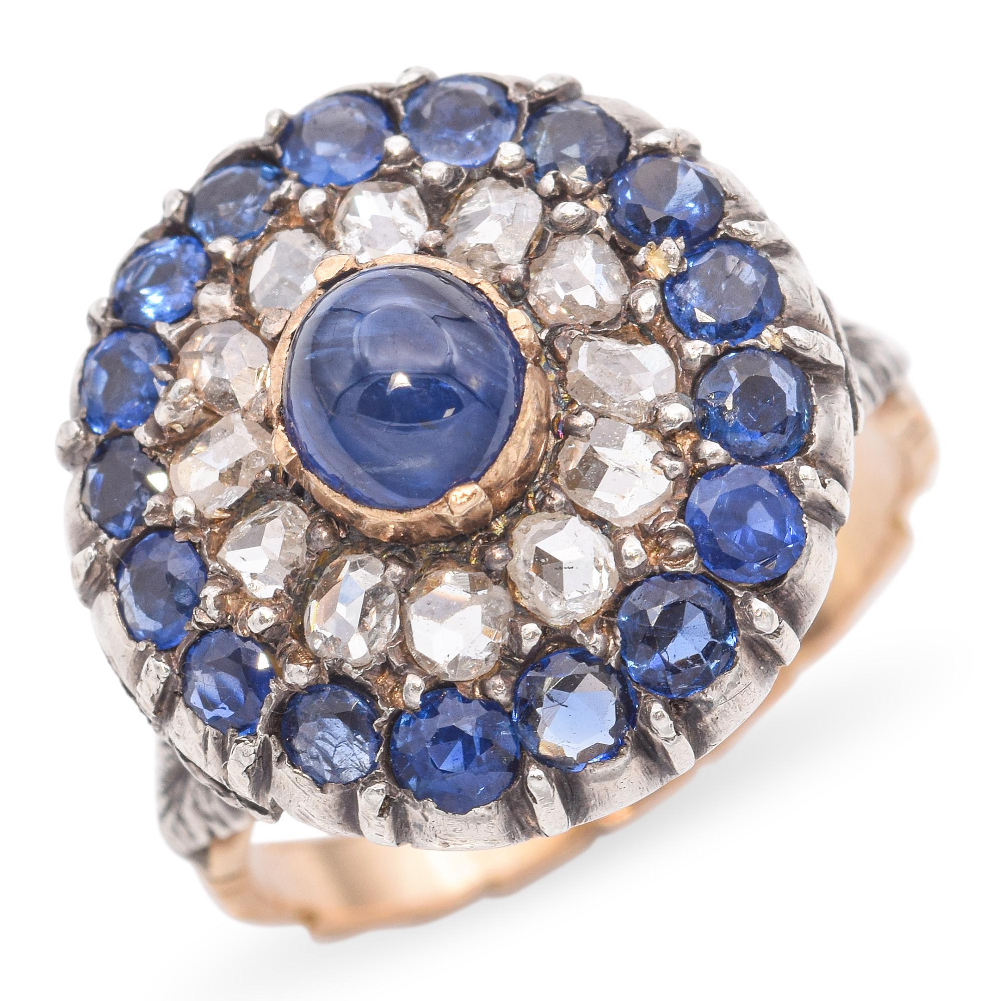 An exquisite example of 19th-century craftsmanship, this antique Victorian ring is fashioned in 18k gold with a sterling silver top—a hallmark of the period’s jewelry design. At its center sits a mesmerizing cabochon sapphire, surrounded by a