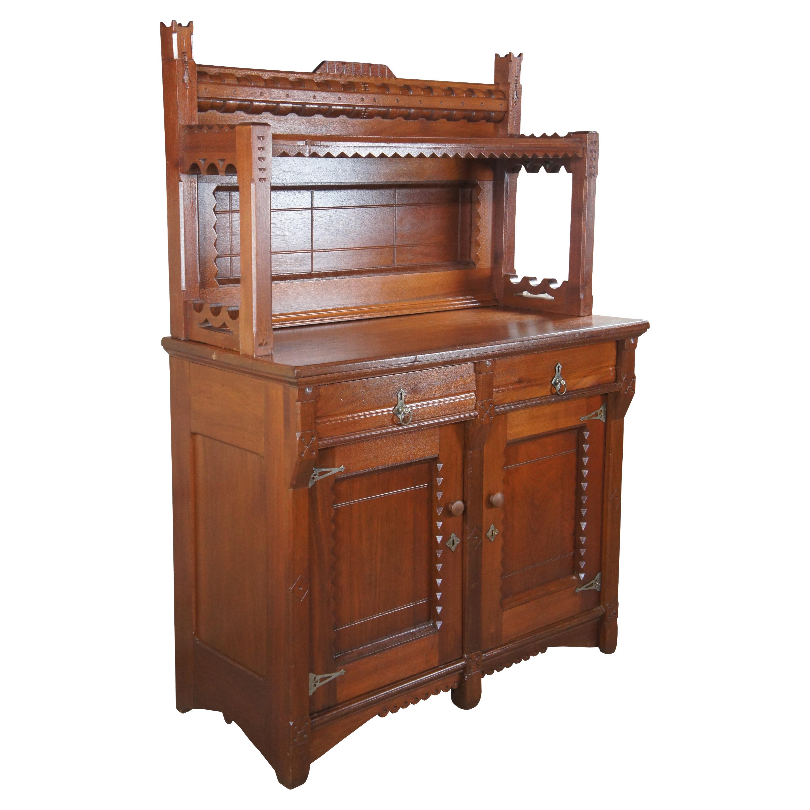 A beautiful Victorian era Eastlake sideboard, server or dry bar. Made from walnut with a uniquely carved backsplash featuring sawtooth and contoured molding. The paneled backing can be removed and replaced with a mirror. The base features two hand
