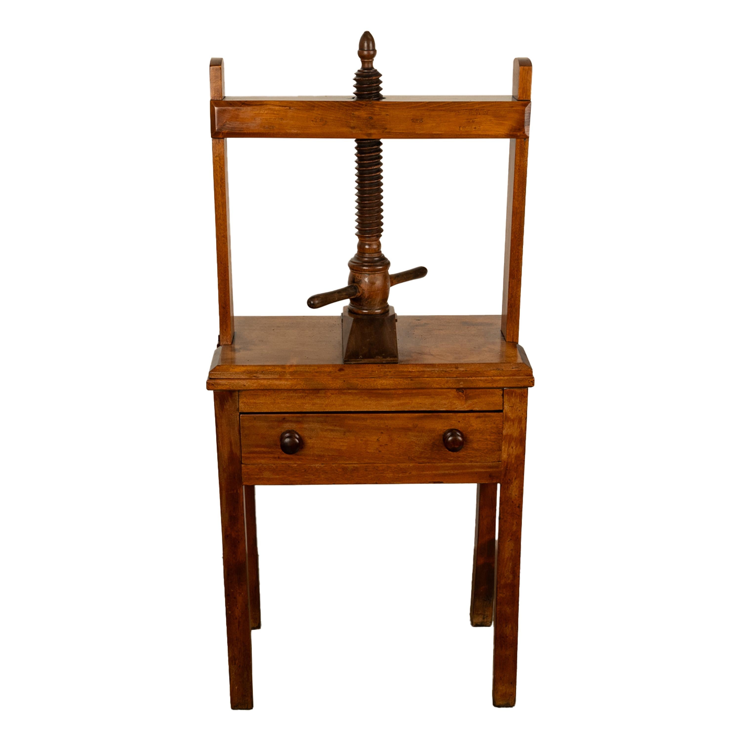 A good antique mahogany linen or book press by Tomas Bradford & Co, London & Manchester, circa 1860.
The press having an upper frame with a large turned wooden screw with a turning handle that operates a platform to apply pressure to the press, the