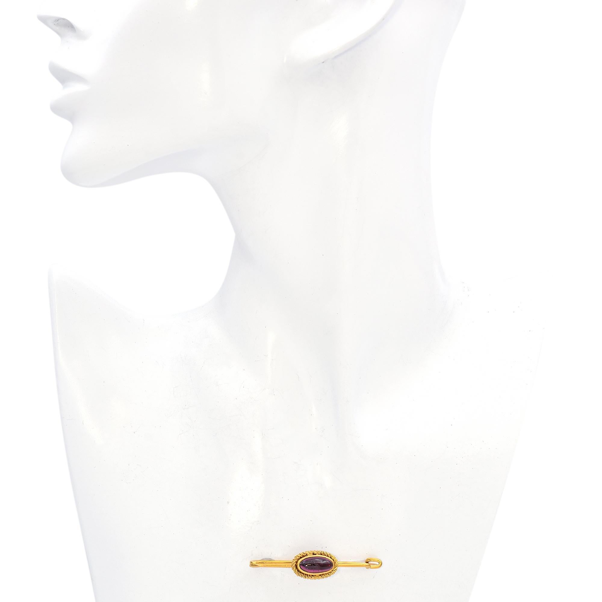This elegant brooch captivates with its refined Victorian design. Crafted in yellow gold, it showcases a central cabochon-cut garnet in a deep red hue, encased in a twisted gold rope setting that enhances its rich color.

Weight: 4.1 Grams
Stone: