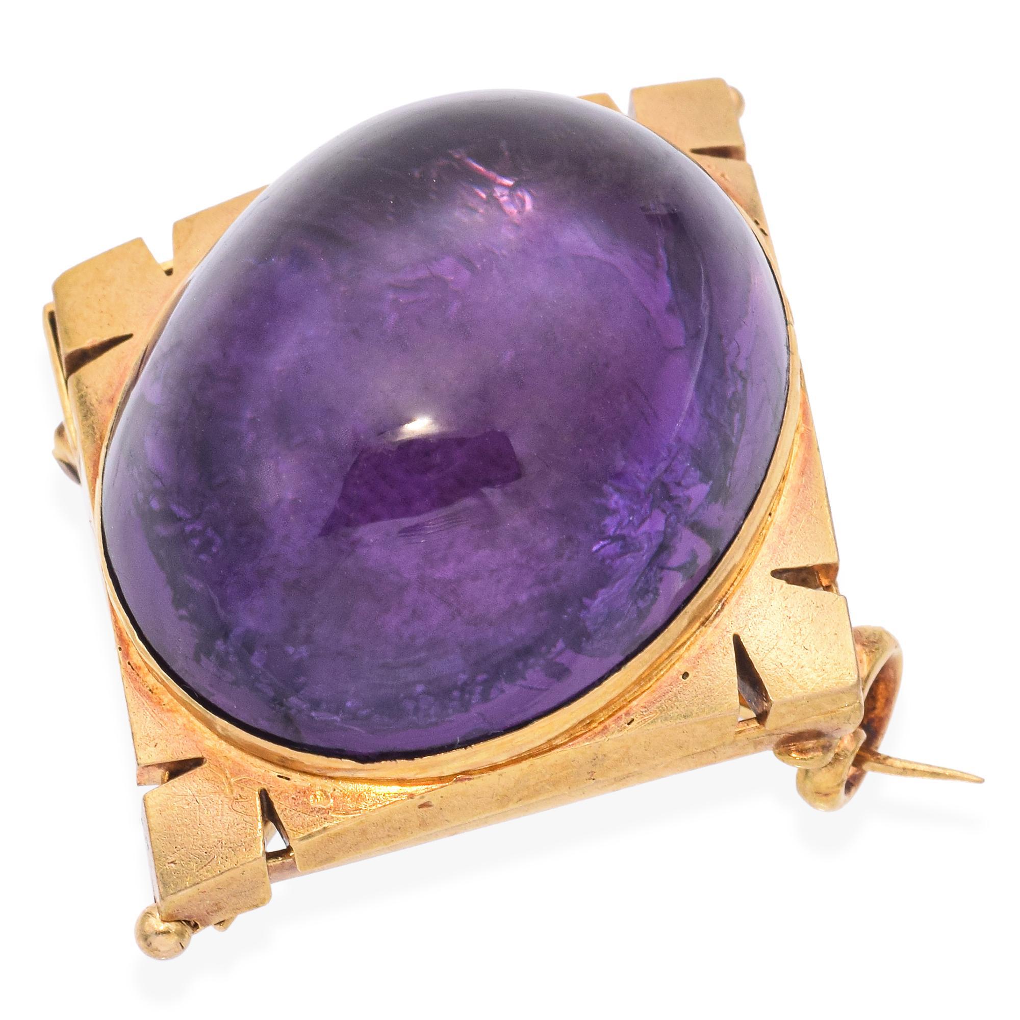 A striking and elegant brooch features a large, oval-shaped amethyst cabochon with a deep purple hue. The amethyst is set in a geometric gold frame, adding a touch of sophistication.

Weight: 25.1 grams 
Stone: 35.6ct Amethyst Cabochon