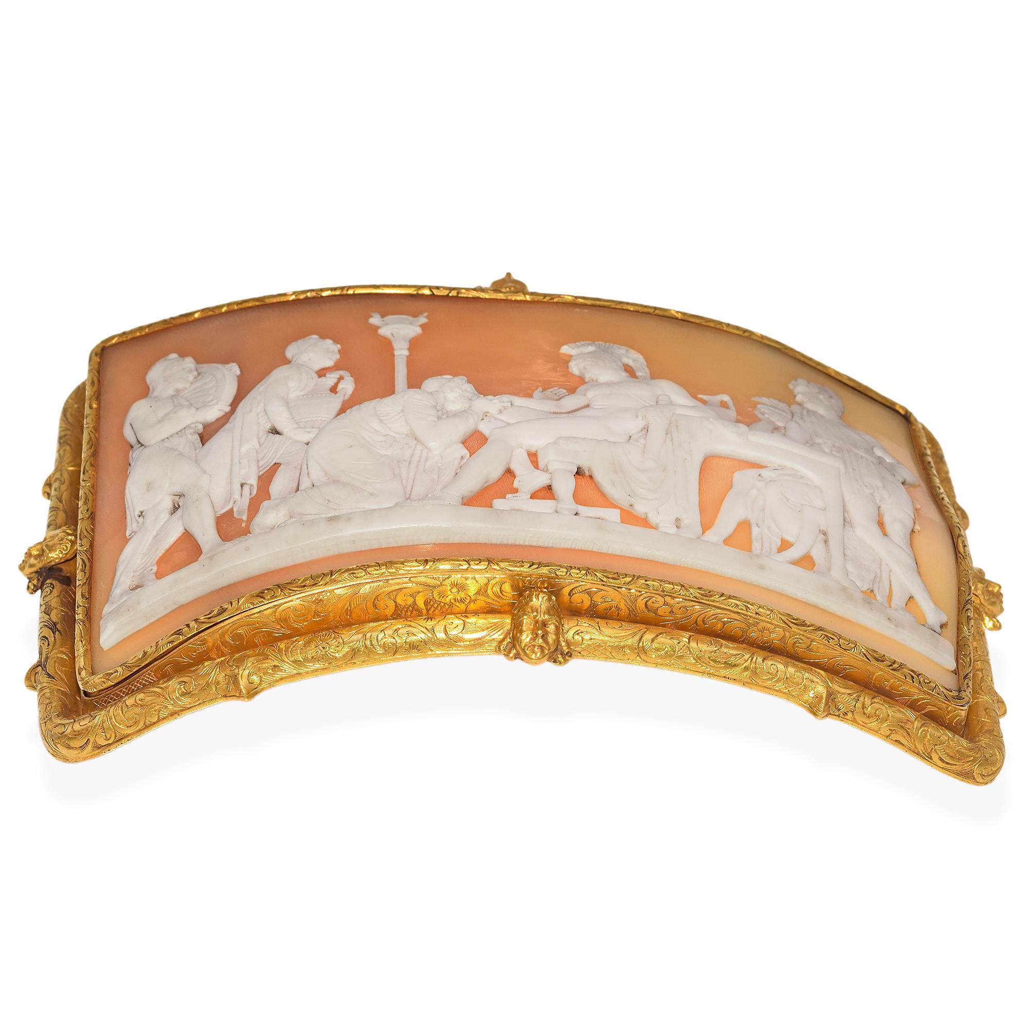 Cette boucle de ceinture en or 23 carats est ornée d'un camée magistralement sculpté, placé dans un cadre en or opulent orné de têtes de chérubins sur chacun des quatre côtés. Le camée dépeint une scène narrative riche qui semble faire écho aux