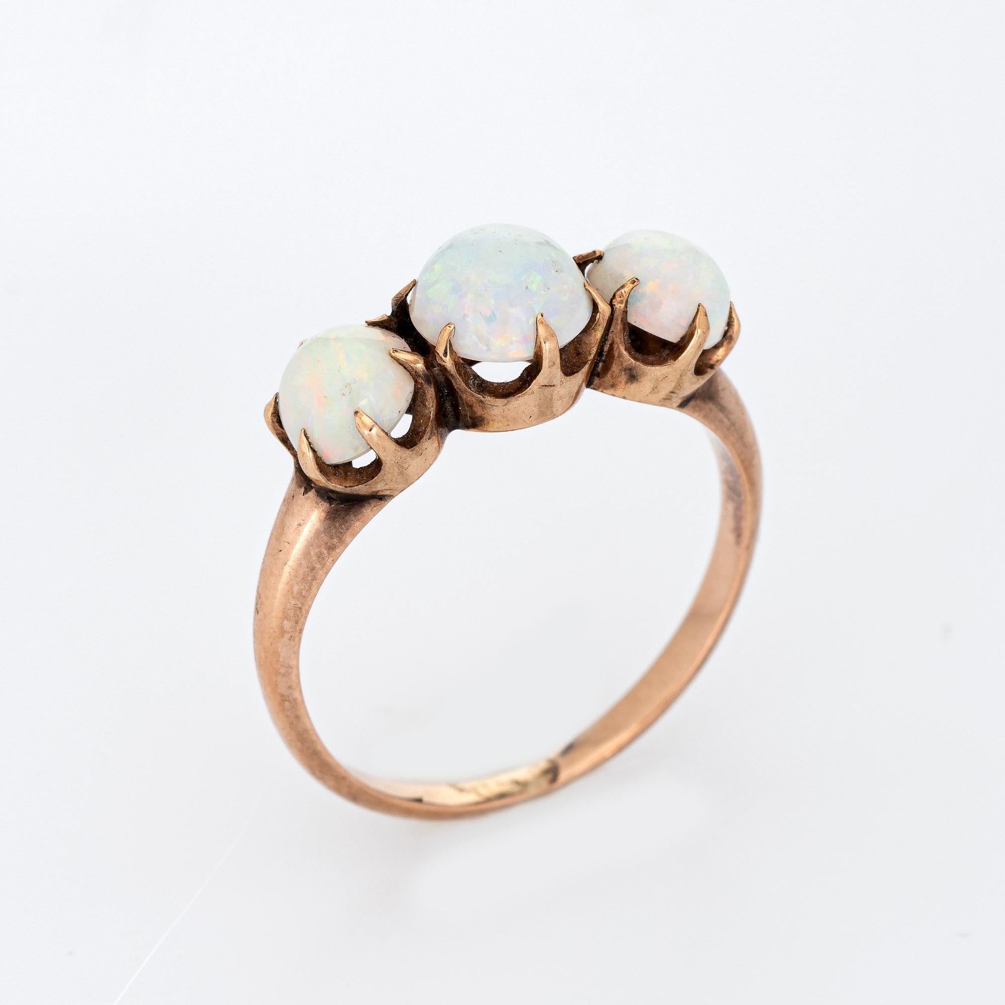 Finely detailed antique Victorian 3 trilogy opal ring (circa 1880s to 1900s) crafted in 10 karat rose gold. 

Cabochon cut natural opals measure 5mm to 6mm and total an estimated 2.20 carats. The opals are in very good condition and free of cracks