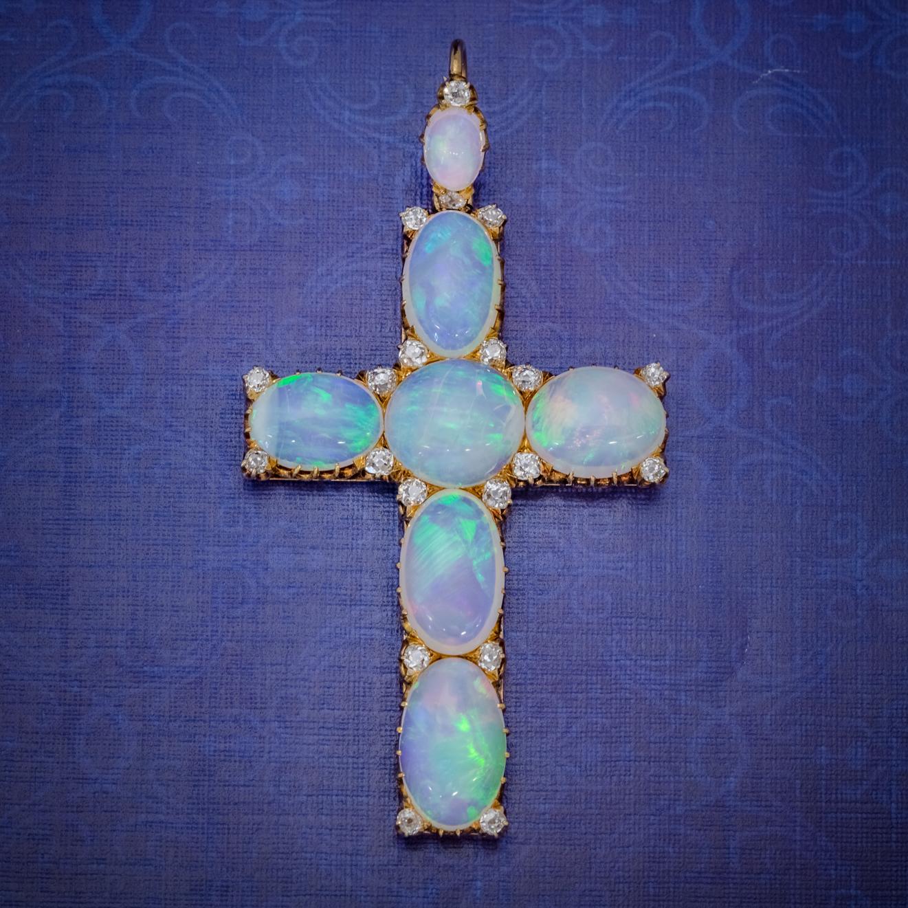 This spellbinding Antique Victorian cross pendant is set with seven stunning natural Opals which are a kaleidoscope of rainbow colours shimmering and changing colours with the light. Each stone radiates blues, pinks, greens and an inner orange and