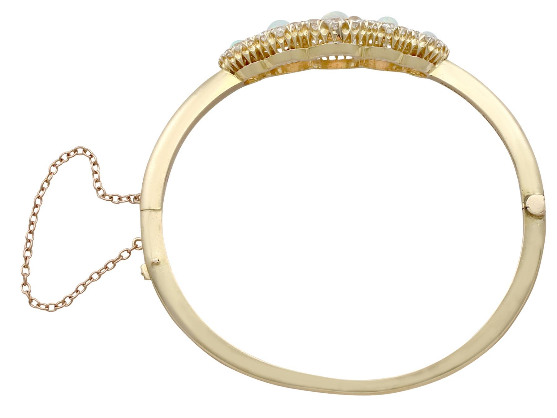 A stunning antique Victorian 3.92 carat opal and 3.25 carat diamond, 18 karat yellow gold bangle; part of our diverse antique jewelry and estate jewelry collections.

This stunning, fine and impressive Victorian opal bangle has been crafted in 18k