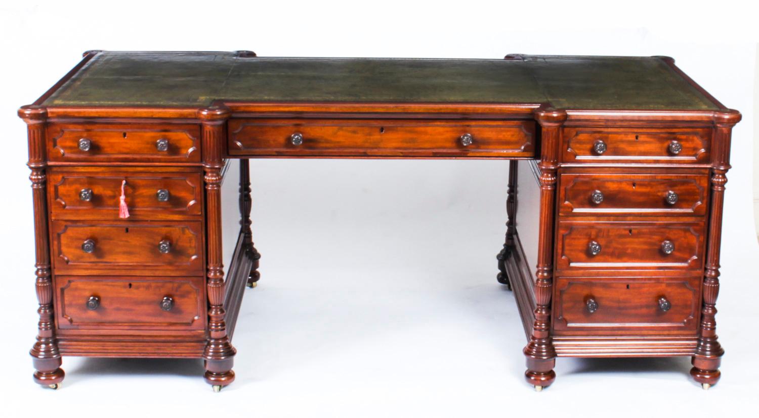 This is a very fine antique Victorian flame mahogany inverted breakfront partners pedestal desk, circa 1880 in date.

The shaped rectangular top features a stunning inset gold tooled green leather writing surface. 

It is fitted with three