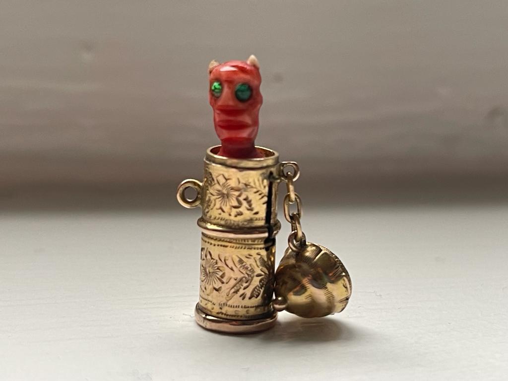 A rare antique charm from the early 18th century English Victorian time.
This very collectible piece consists of a gold capsule that is stamped and holds a small devil totem hidden inside. During the Victorian era, many jewelry elements were