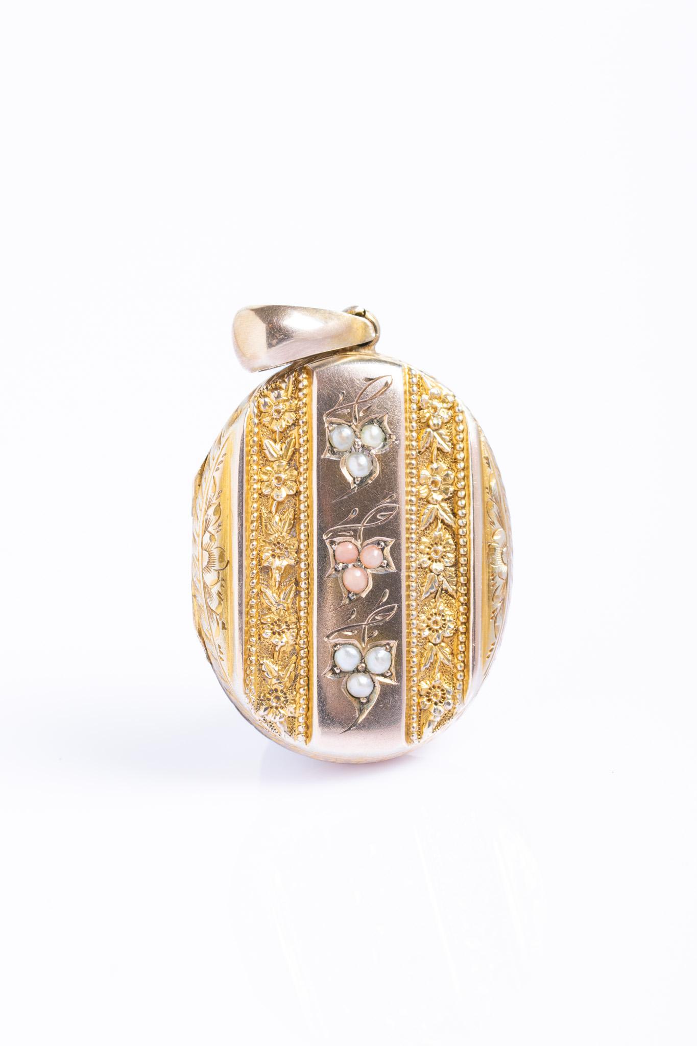 Un grazioso medaglione vittoriano in oro 9ct decorato con perle e corallo. Il pannello centrale in oro 9ct presenta un motivo floreale accentuato da perle lucenti e corallo sottile. Un disegno floreale simile si trova sul retro, con un piccolo