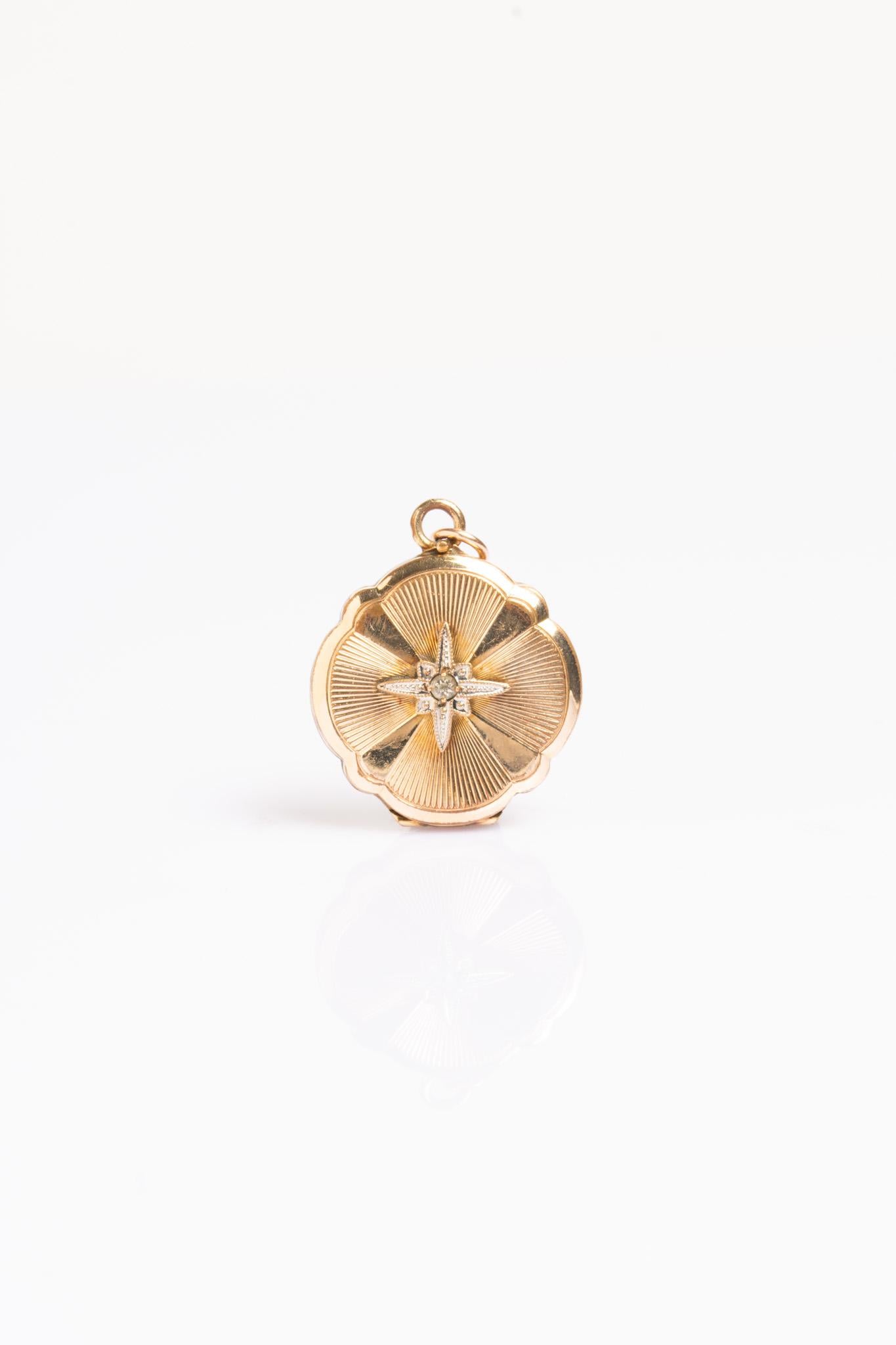 This exquisite Victorian-era gold locket features a delicate floral outline and a beautifully engraved radiating sunburst pattern and a raised star motif set with a shimmering rose-cut diamond. The star has long represented guidance and protection,