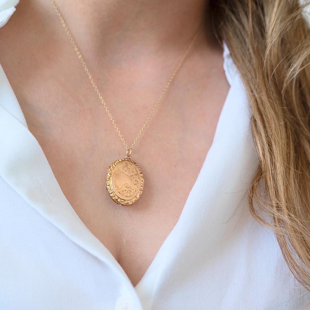 This beautifully detailed antique Victorian oval locket is crafted in warm-toned gold—richer than yellow gold but not quite rose gold. Its balanced hue pairs effortlessly with a yellow gold chain, chosen to complement the natural warmth of the