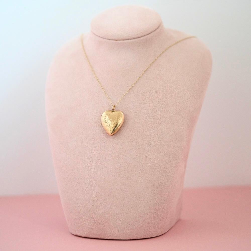 Ce magnifique médaillon en forme de cœur de style victorien reflète le sentiment d'amour et de souvenir de l'époque. Réalisée en or jaune 9ct, la forme arrondie et bouffante est délicatement gravée d'un motif de feuillage entouré d'une bordure en