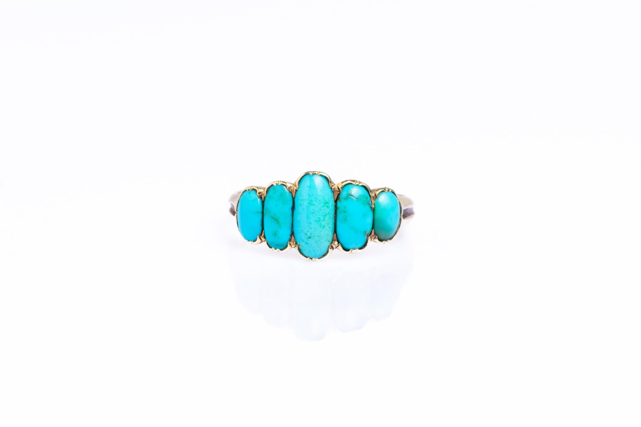 This beautiful antique Victorian ring is set in 9ct yellow gold and has five wonderful blue oval cabochon turquoise in pinched collet closed back settings with reeded shoulders. The turquoise is considered a symbol of friendship and good fortune.
