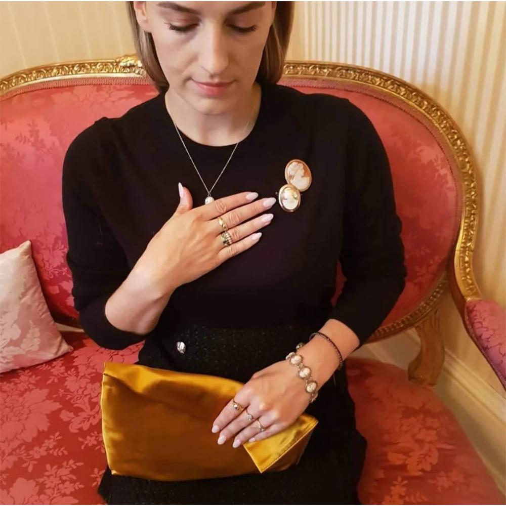 Antique Victorian cameo brooch featuring a Grecian women carved from a peach coloured shell set in a 9ct rose gold mount. The brooch is secured with an open 'c' clasp and for extra security a safety chain.

Cameo jewellery became popular during the