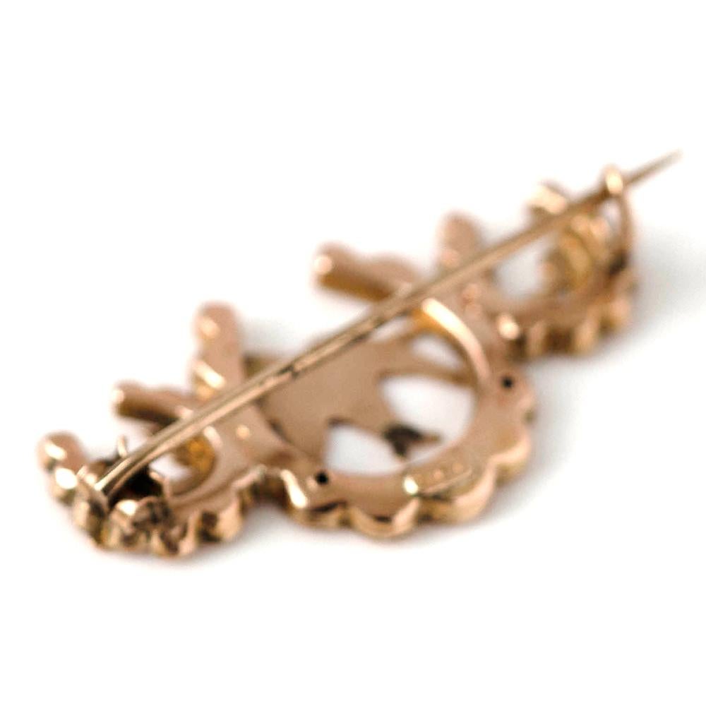 Experience the romantic symbolism of the Victorian era with this stunning 9ct rose gold brooch. Beautifully crafted, the piece showcases three horseshoes, traditionally seen as symbols of luck and protection. At its center, a delicately rendered