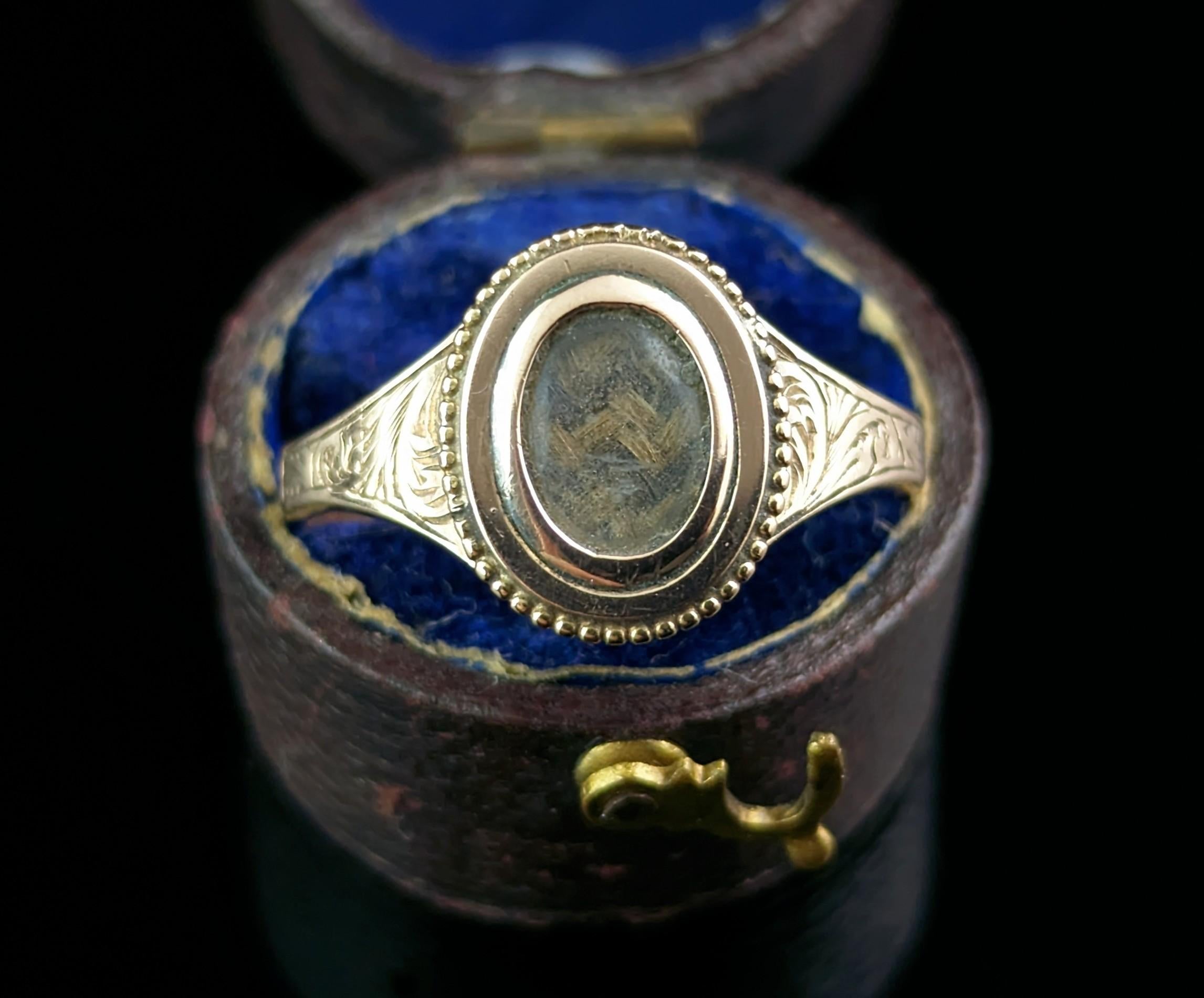 A charming antique Victorian 9cr gold and hairwork mourning ring.

A beautiful Victorian piece in a nice classic design.

The face of the ring has a small oval glazed locket panel enclosing a lock of brown tightly woven hair.

The shoulders have a