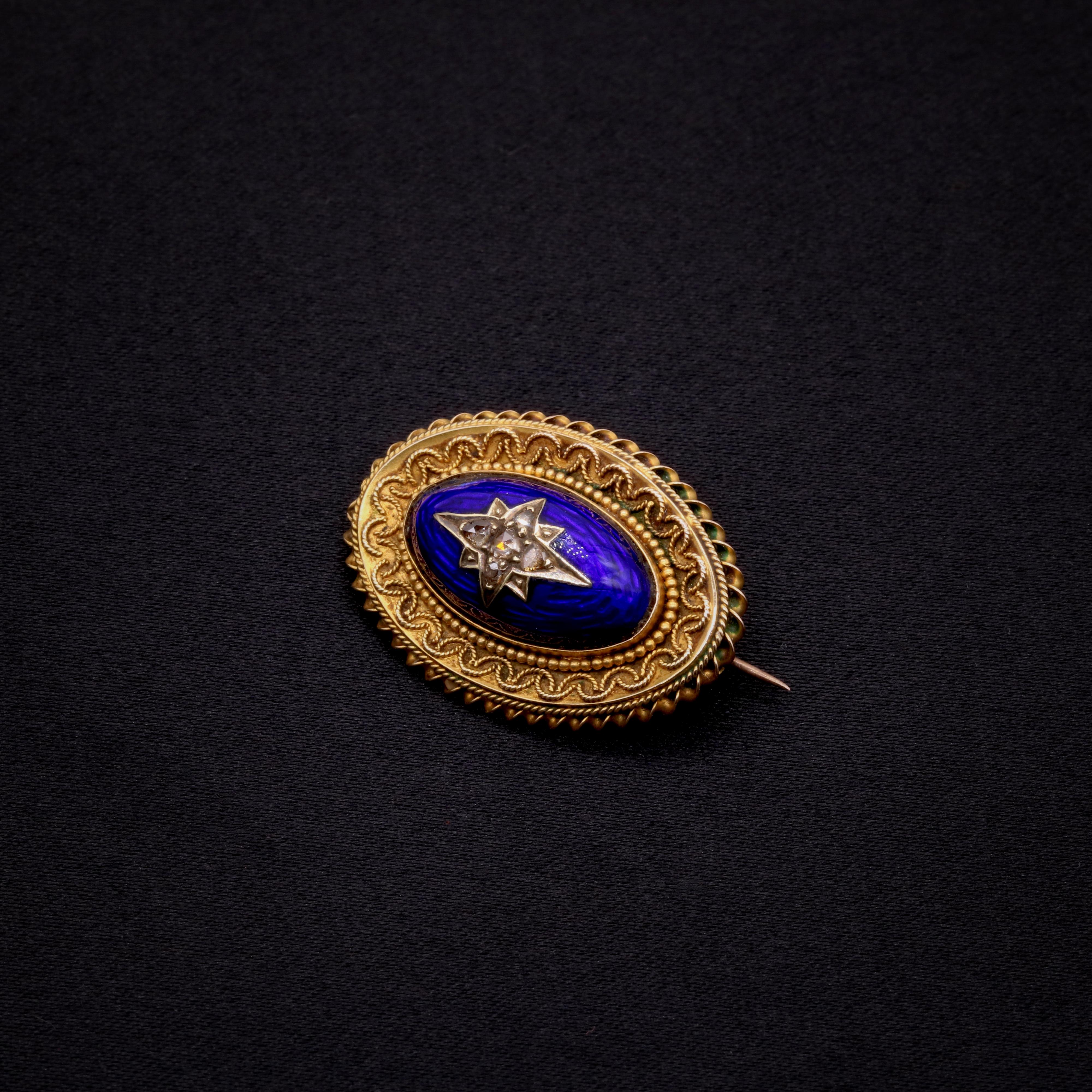 Broche victorienne en diamant, émail bleu et or jaune, sertie de cinq diamants taillés en rose, émail bleu, sertie en or jaune 9 carats, avec épingle et ferrures en or jaune 9 carats.

Cette broche victorienne complexe est sertie au centre d'une