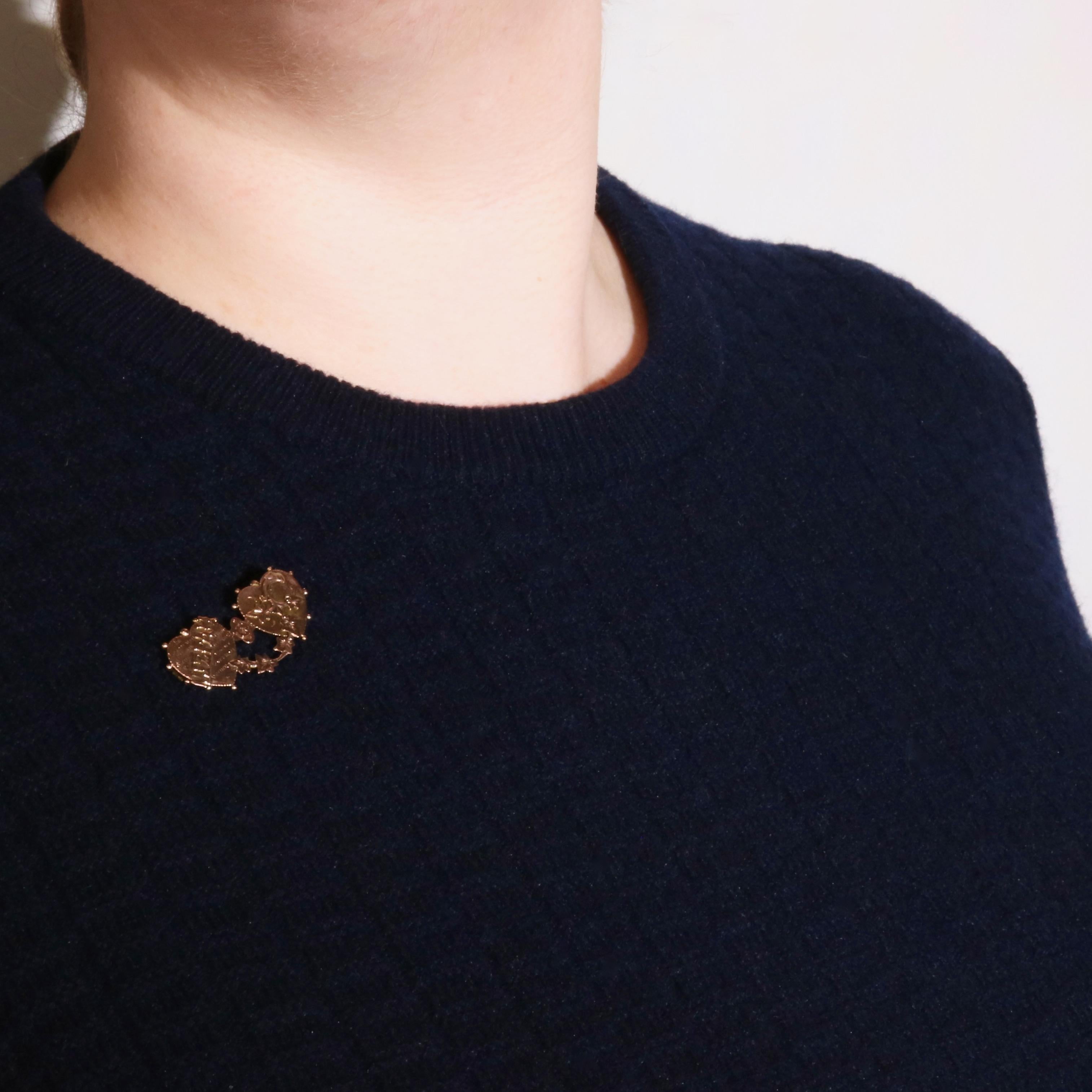 A rose gold brooch, formed in the shape of two connected hearts, in 9 karat rose gold, with pin and fittings in 9 karat rose gold.  

This lovely brooch is beautiful in its Victorian design. Fashioned as two hearts joined with a flower, the