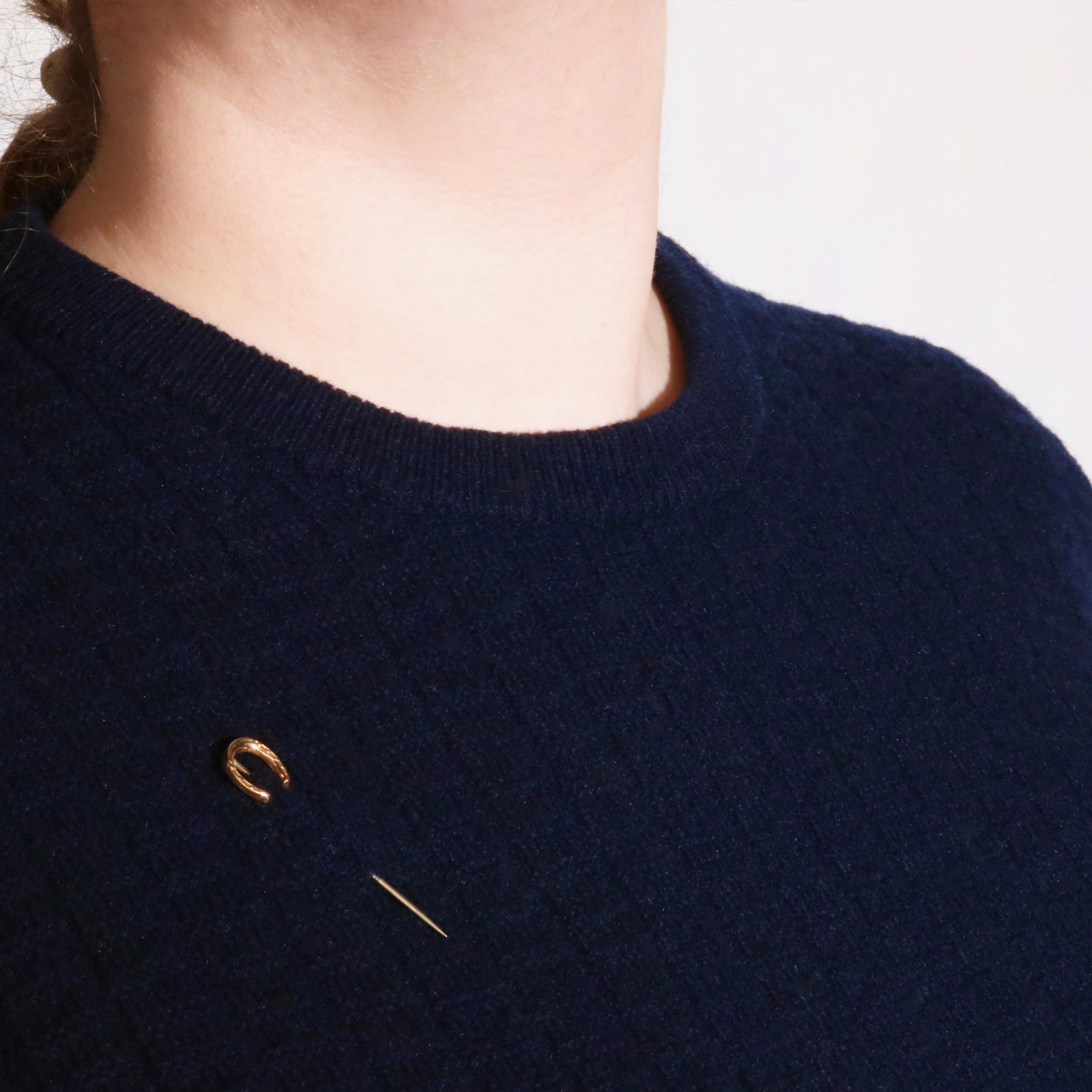 An antique stick pin in yellow gold and silver, the head of the pin formed as a horseshoe, crafted in 9 karat yellow gold, to a pin of silver. 

The horseshoe (symbolising good luck and protection) is simply, yet effectively designed. An elegant