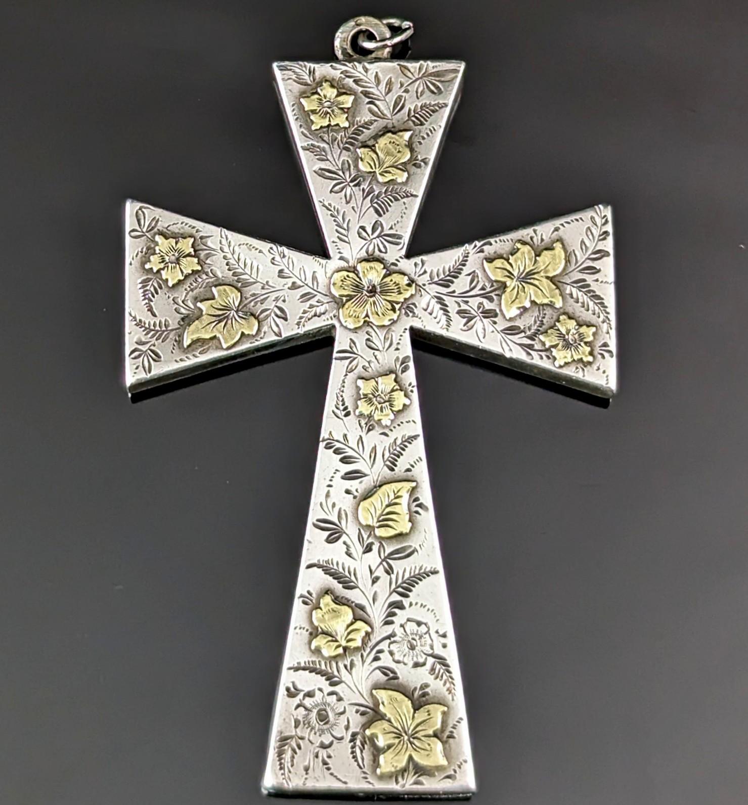 Ce magnifique pendentif en forme de croix de l'époque victorienne esthétique est à la fois saisissant et délicat.

Il s'agit d'un pendentif en forme de croix de grande taille, réalisé en argent sterling et orné de feuilles et de fleurs en or jaune,