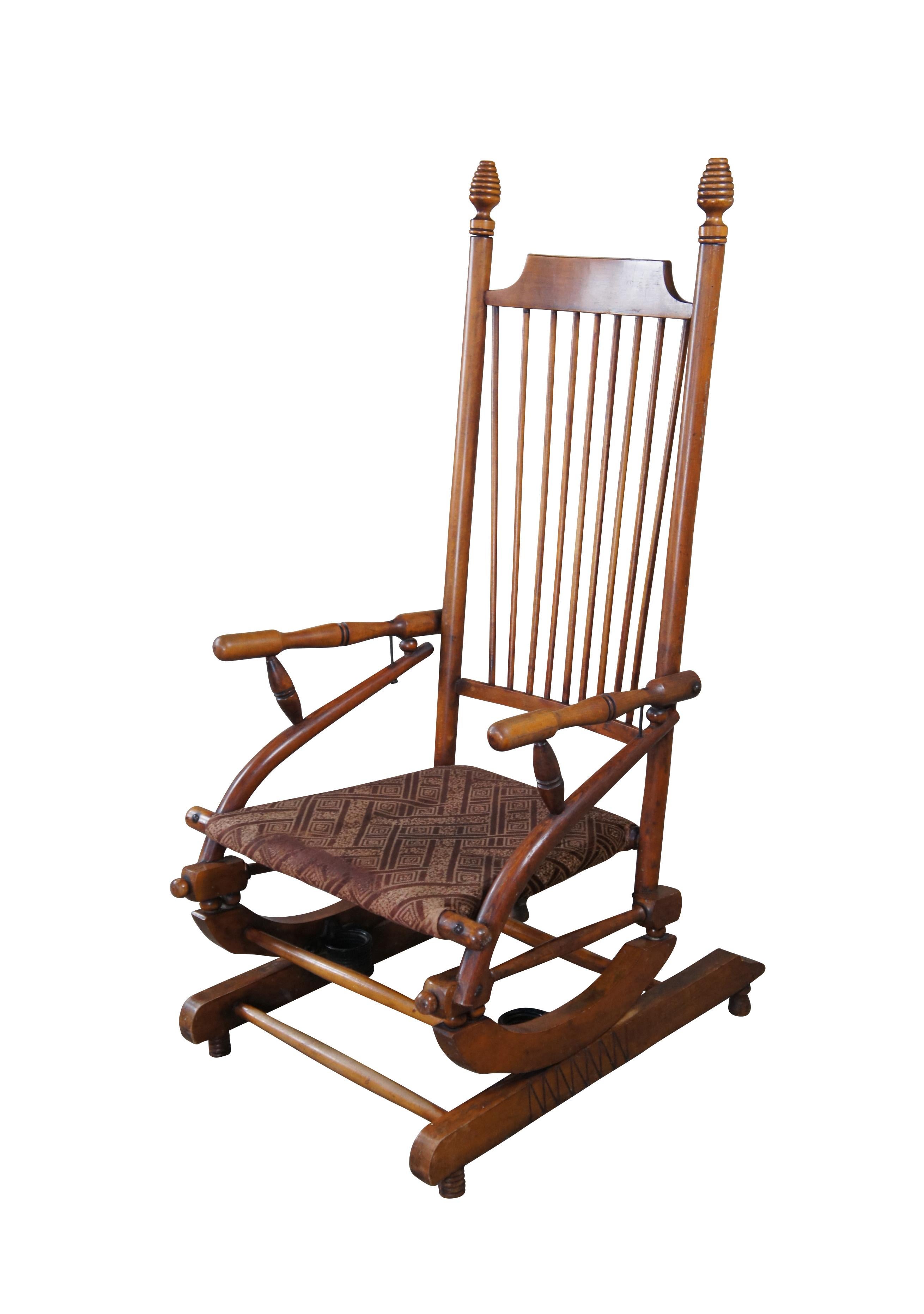 An intriguing Aesthetic Periiod platform rocking chair.  Made from oak with a spindled back, ribbed and graduated (beehive) finials, bentwood and turned arms and a cloth seat.  

Dimensions:
25