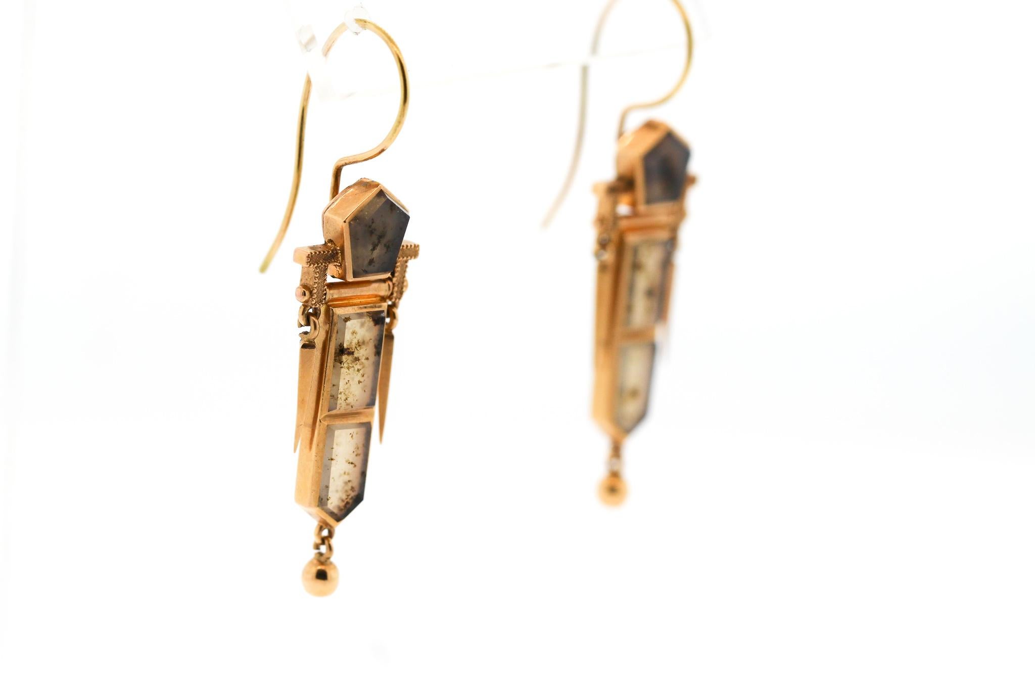 Sculptural and elegant antique Victorian moss agate pendant earrings made in 14k yellow gold. These earrings center on three pieces of moss agate, with gold darts hanging down on either side. A small round ball completes the bottom of the earring.