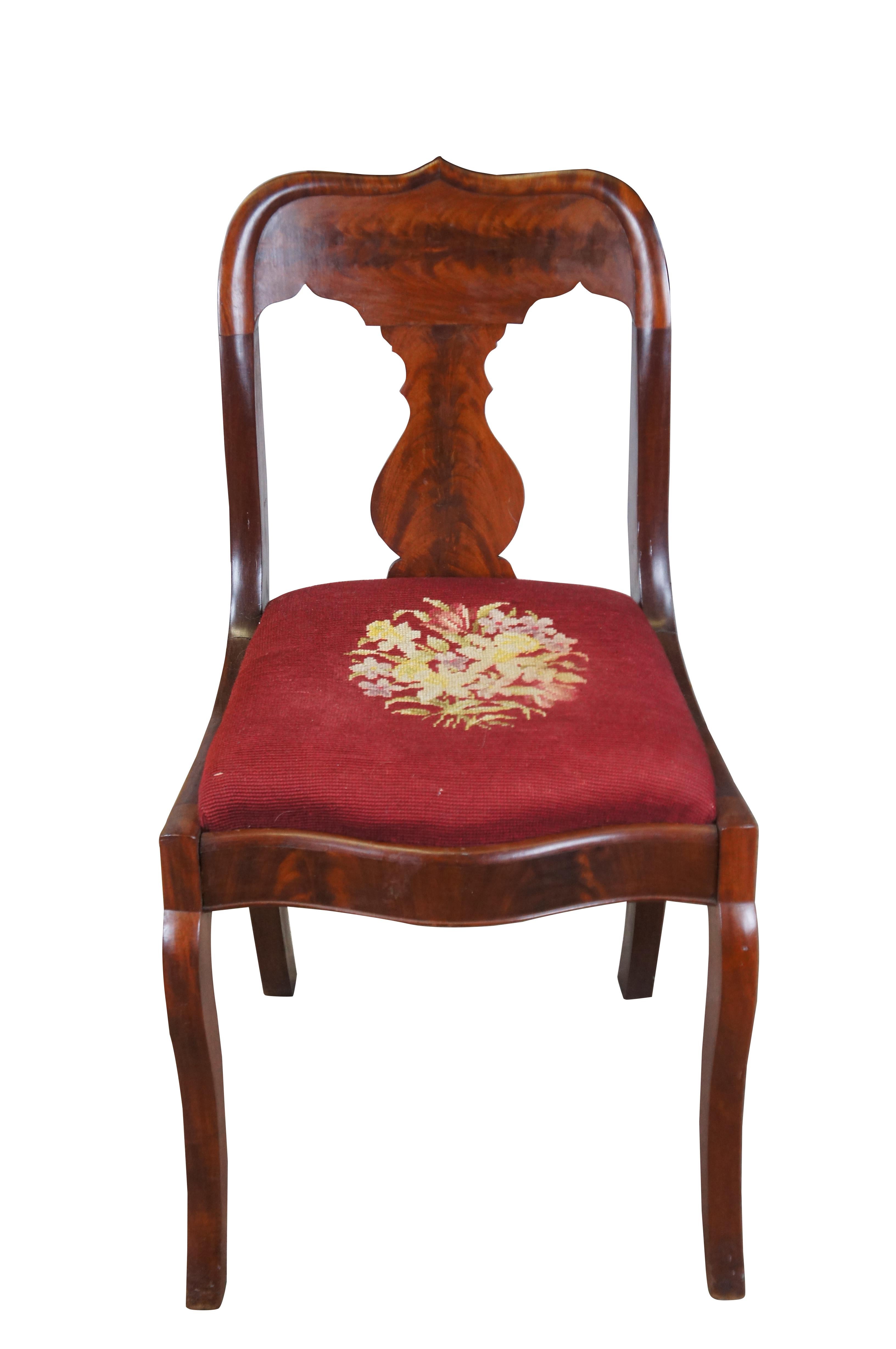 Charming antique American Empire side chair. Features a mahogany frame with crotch mahogany veneer. The chair showcases an ornate crest rail with vase shaped splat, serpentine apron and floral needlepoint seat.

Dimensions
18