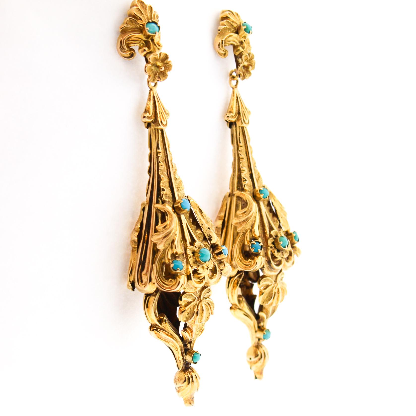 A pair of dramatic Victorian turquoise 14k yellow gold repousse pendant earrings likely made in the United States around 1880. The long dimensional earrings are in incredible condition as it has no dents or hasn't been crushed in all these years.