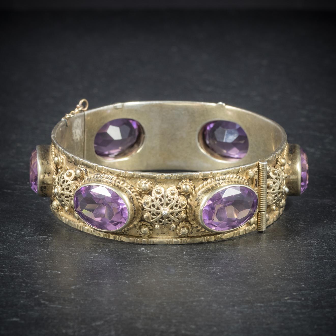 This grand antique Gold gilt Amethyst bangle is Victorian, Circa 1900

The unique piece is set with six fabulous Amethysts which add up to an impressive 48cts

Set in a fabulous Gold gilt setting with beautiful ornate detailing and fretwork 

Fitted