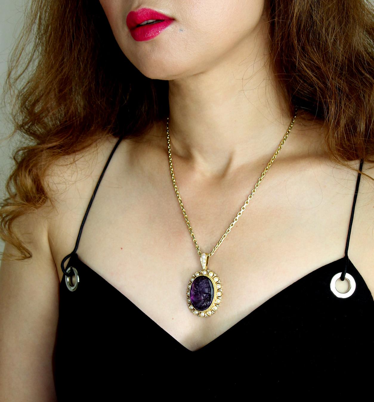 Antique, Victorian, an exquisitely carved amethyst cameo pendant with a diamond and natural pearl surround. A filigree, pearl and rose-cut diamond border frames the carving of a female head and shoulders in profile. The articulated pendant loop is