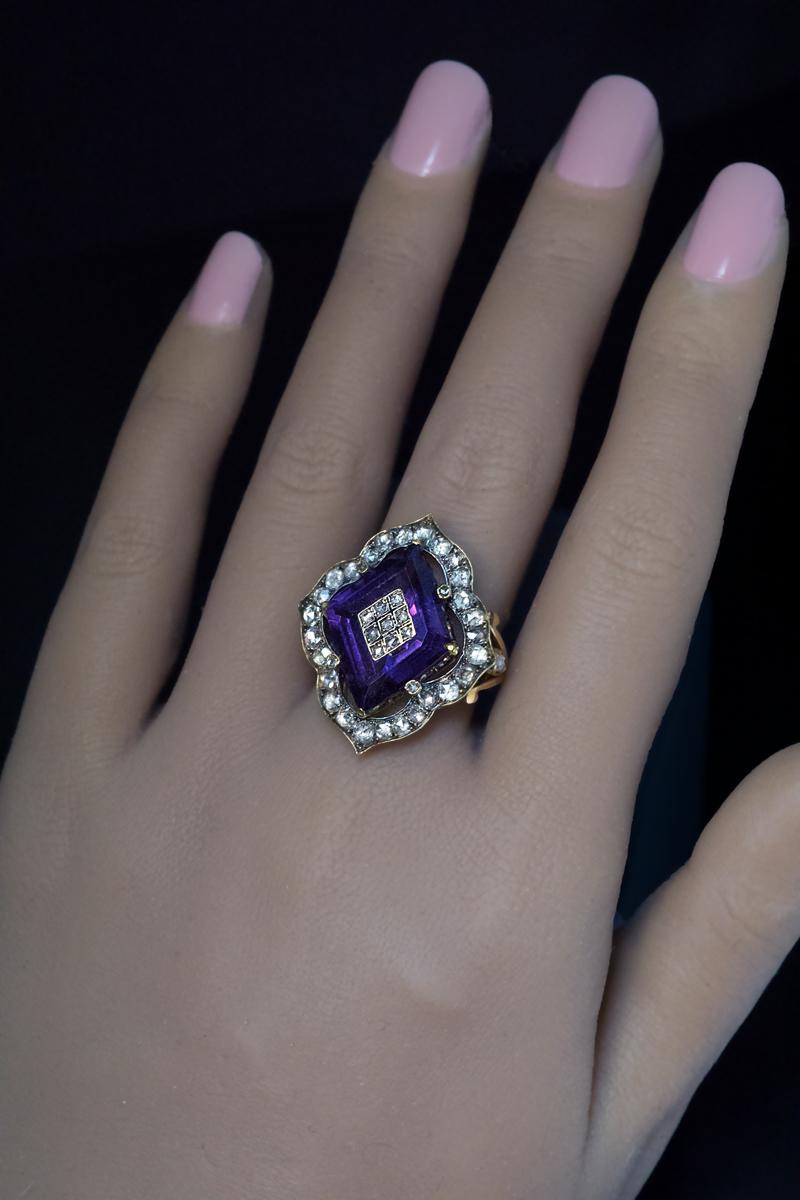 Russian, circa 1880s-1890s.
This chunky Victorian era gold and silver ring features a large step-cut diamond shaped amethyst (20 x 15 x 7 mm) inlaid with a diamond encrusted panel accented with black enamel.  The amethyst is set in an ornate bezel