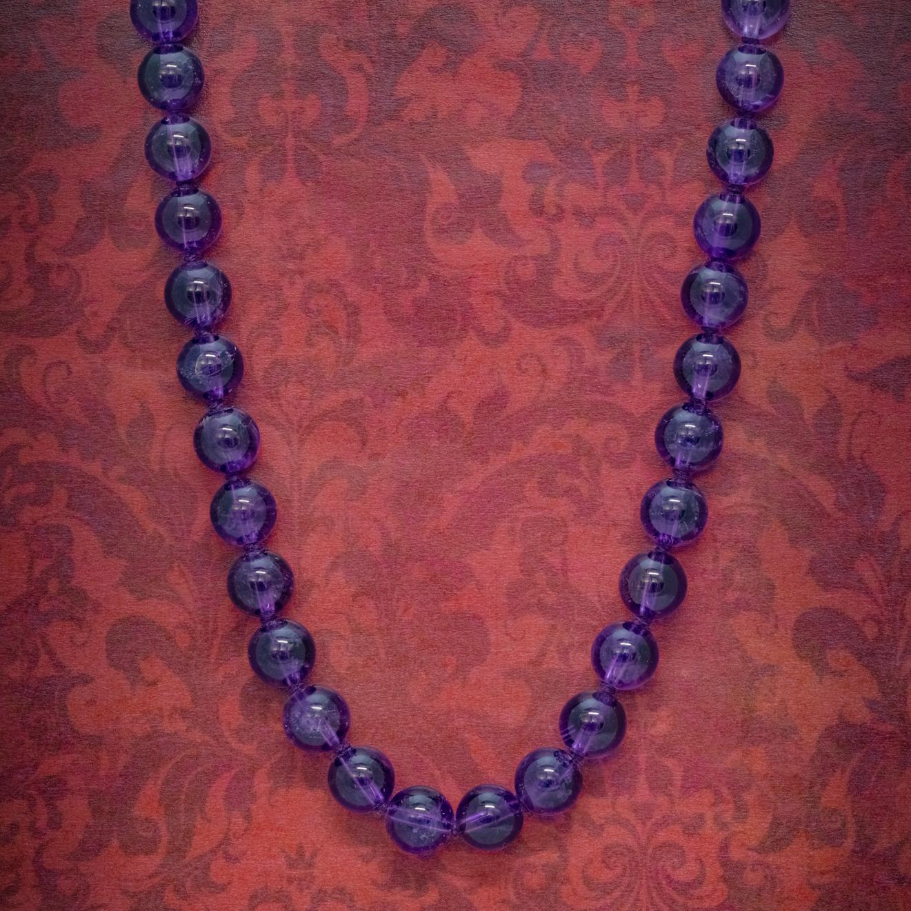 A beautiful Antique Victorian necklace made up of large, polished Amethyst beads which have a lovely vibrant purple hue with the stones raw, natural patterning showing under the surface. 

The beads are knotted in between and held together by a