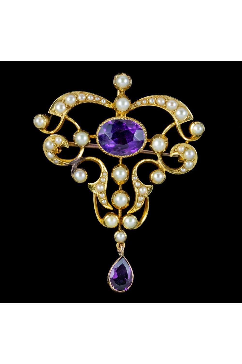 A fabulous antique Art Nouveau brooch from the late 19th Century decorated with gleaming, white pearls and two deep, purple amethysts weighing approx. 2.5ct in the centre and 0.60ct at the bottom. 

The open-work gallery is made up of flowing curves