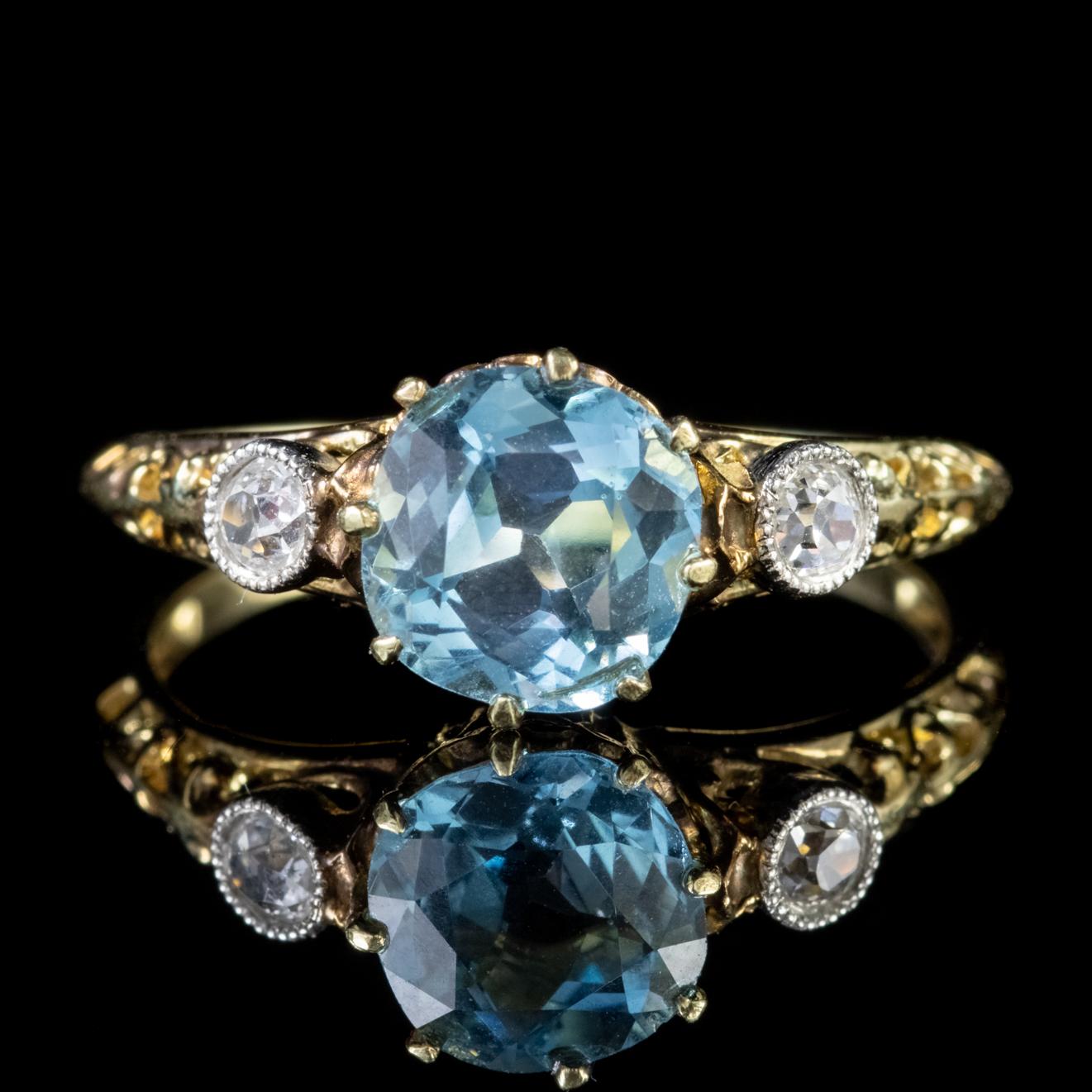 A striking antique Victorian trilogy ring modelled in 18ct Gold and crowned with a beautiful 1.90ct Aquamarine in the centre flanked by two 0.10ct old cut Diamonds. 

Aquamarine is adored for its beautiful clear Ocean blue colour which complements
