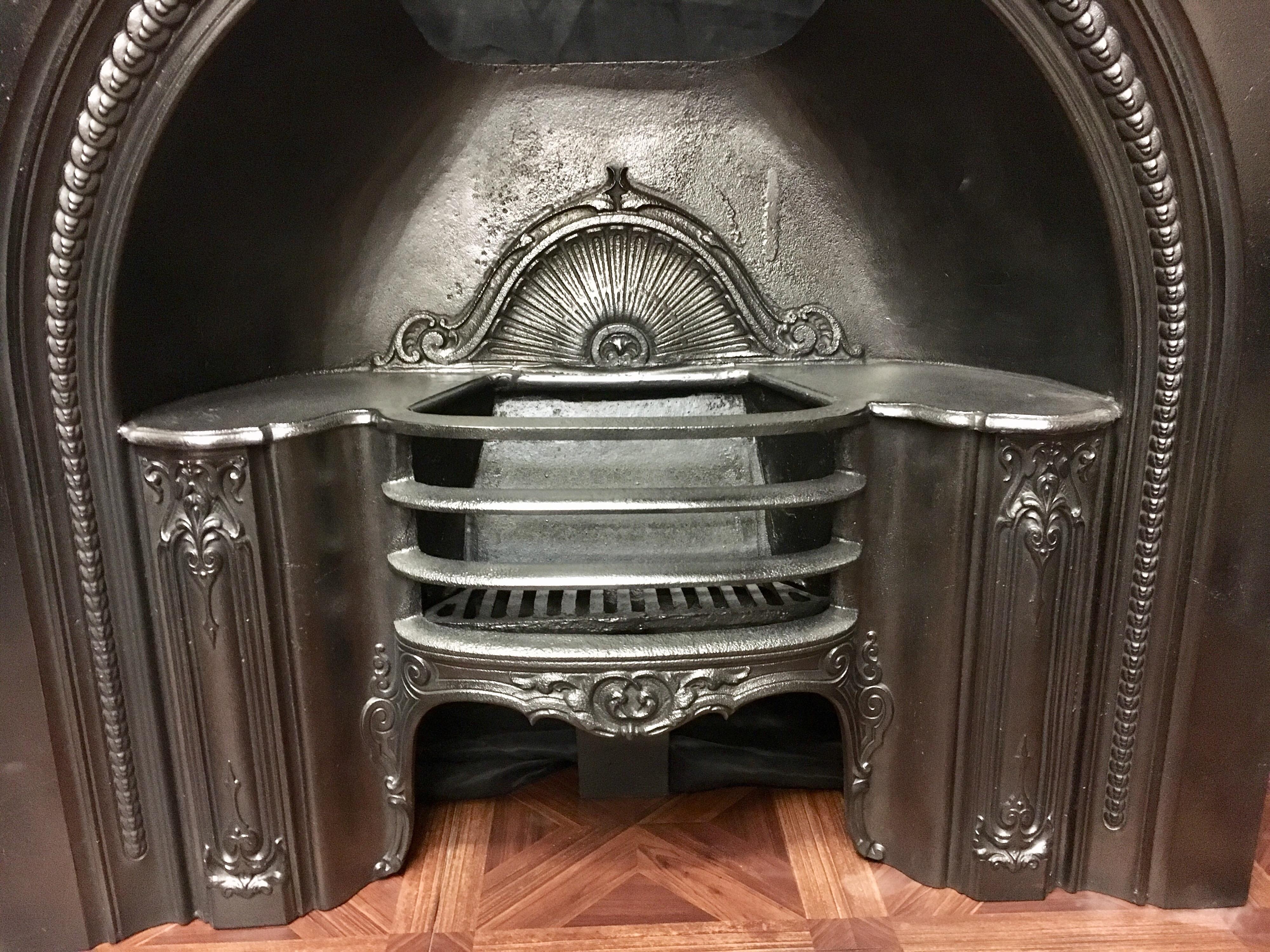A mid-Victorian antique cast iron arched fireplace surround hob grate insert, excellent quality casting, fully refurbished.
English, circa 1870.