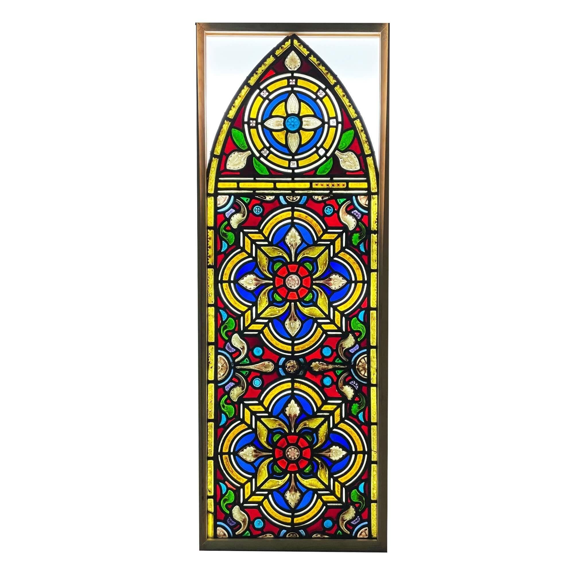An antique Victorian arched stained glass window showcasing a stylised Tudor rose, originally from a church in northern England.

Three hand painted detailed flowers, thought to be the Tudor Rose, sit at the heart of this Victorian era stained glass