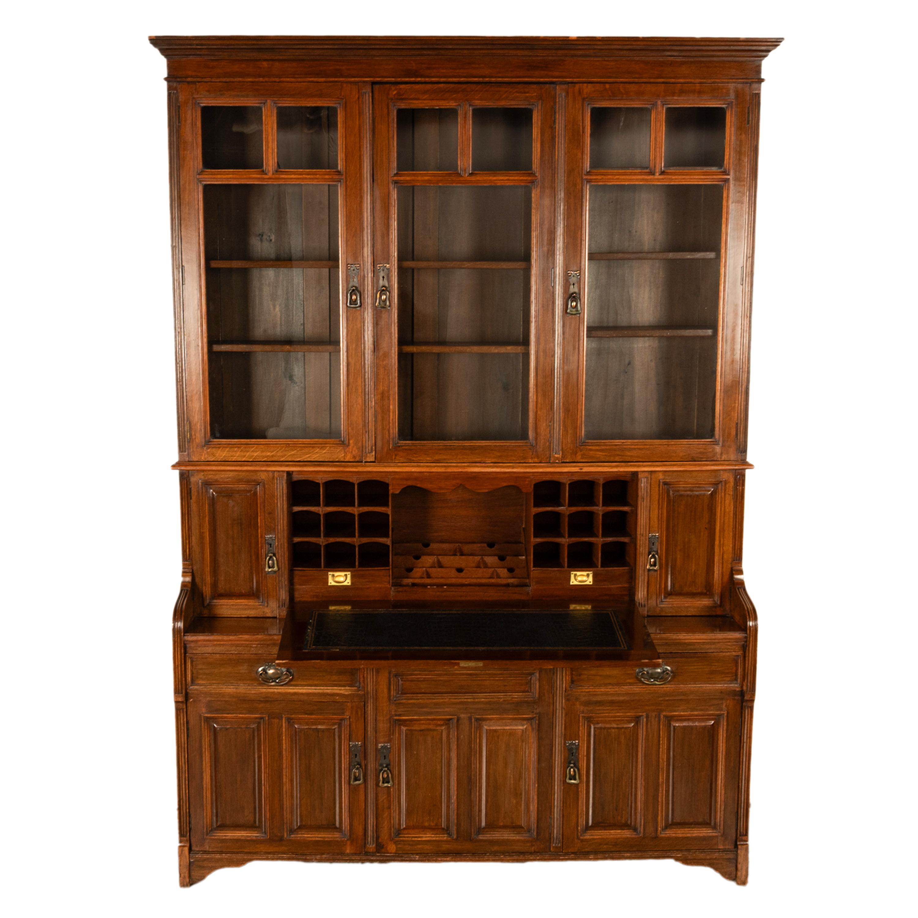 Belle et grande bibliothèque-bureau en chêne sculpté de style Art Nouveau, 1890.
Le secrétaire de la bibliothèque en deux parties est doté d'une couronne étagée sur la partie supérieure et de trois portes vitrées au-dessous, renfermant six étagères